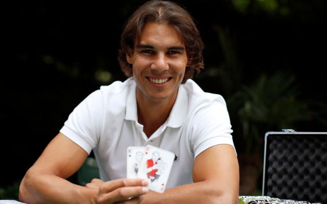 Spanish tennis player Rafael Nadal poses with playing cards depicting some of his 11 Grand Slam victories after an interview with Reuters in Madrid