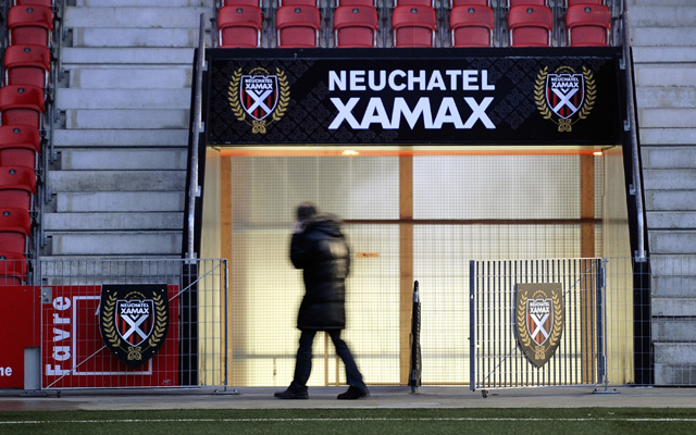 A journalist walks past a sign of Neucha
