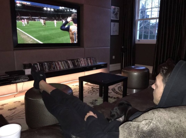 Mesut Ozil watching Arsenal on TV with Balboa the pug
