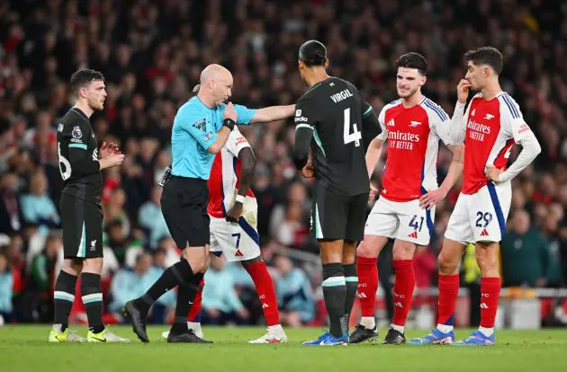 Arsenal and Liverpool players await a referee decision