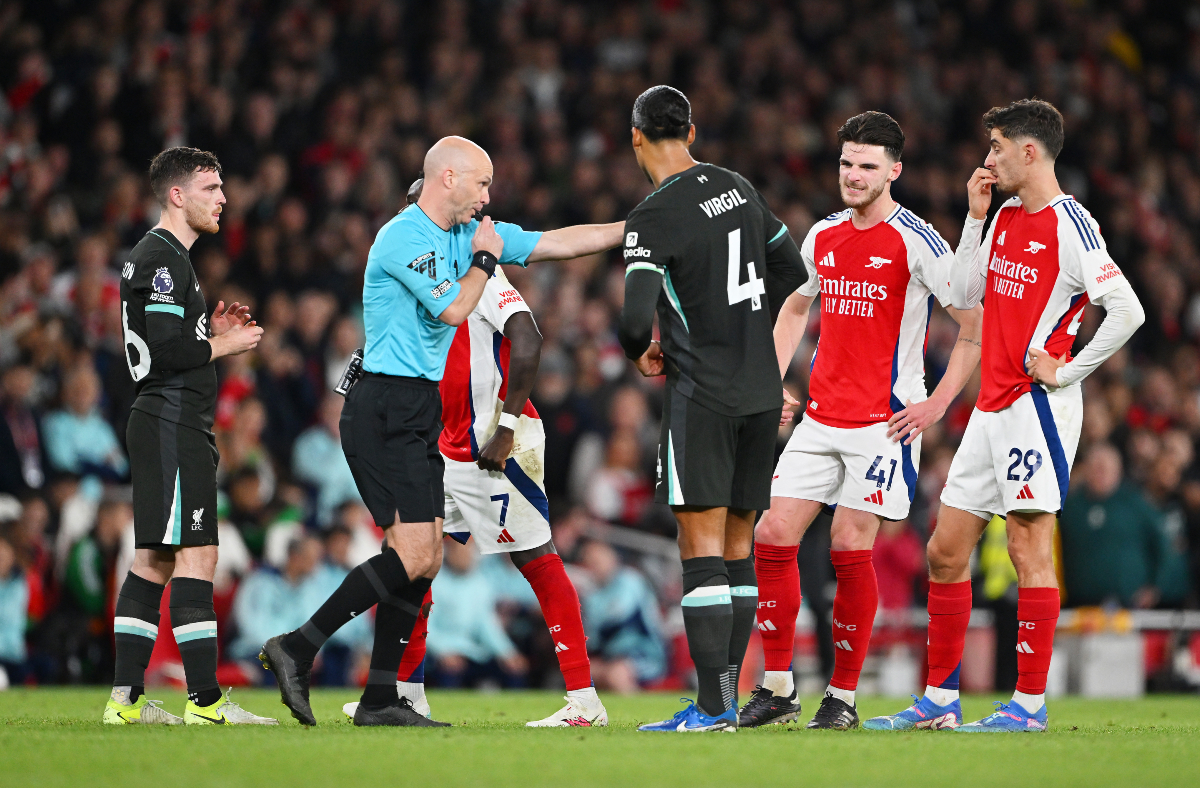 Arsenal and Liverpool players await a referee decision