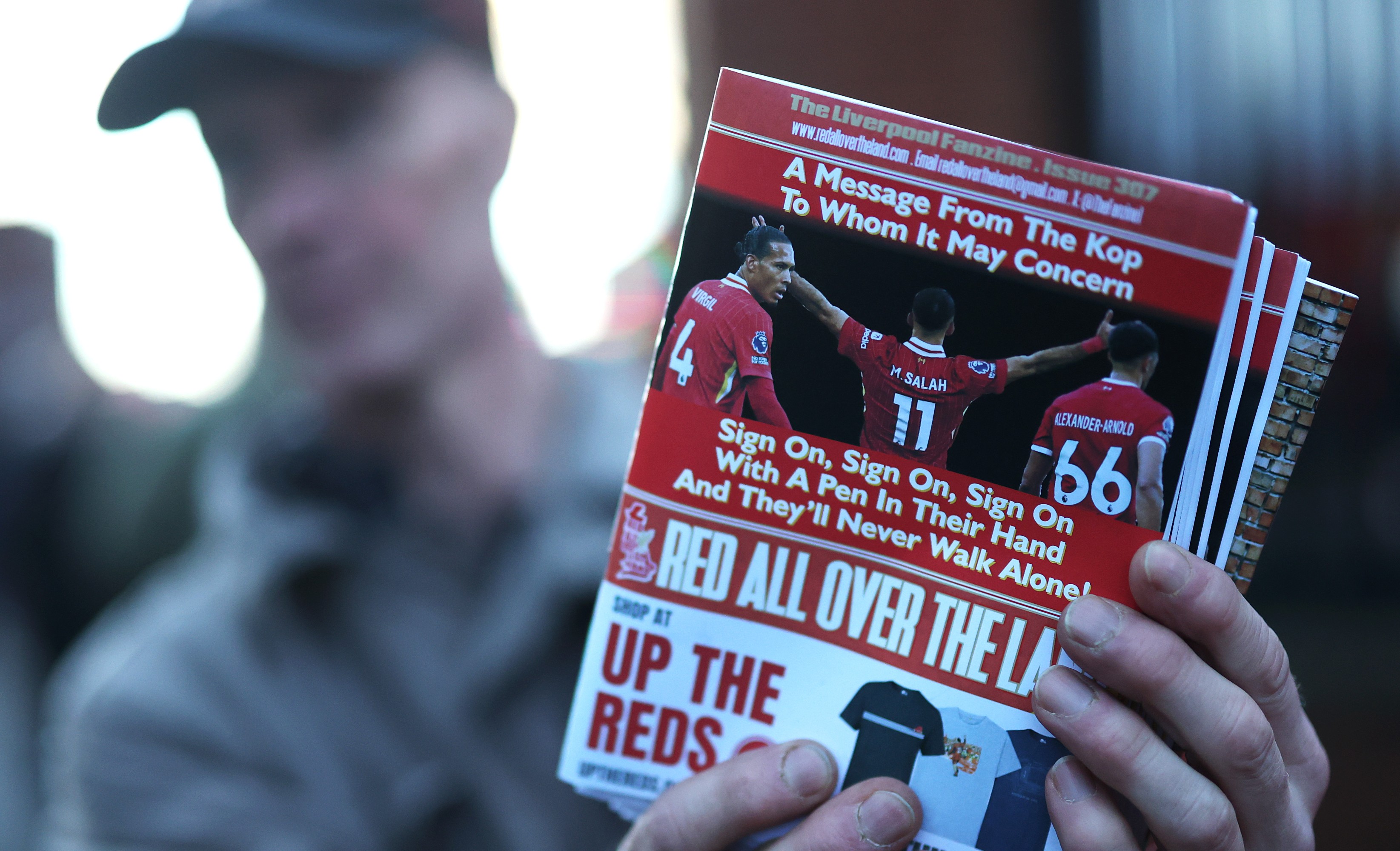 A Liverpool fanzine is seen being sold which features pictures of Virgil van Dijk, Mohamed Salah and Trent Alexander-Arnold