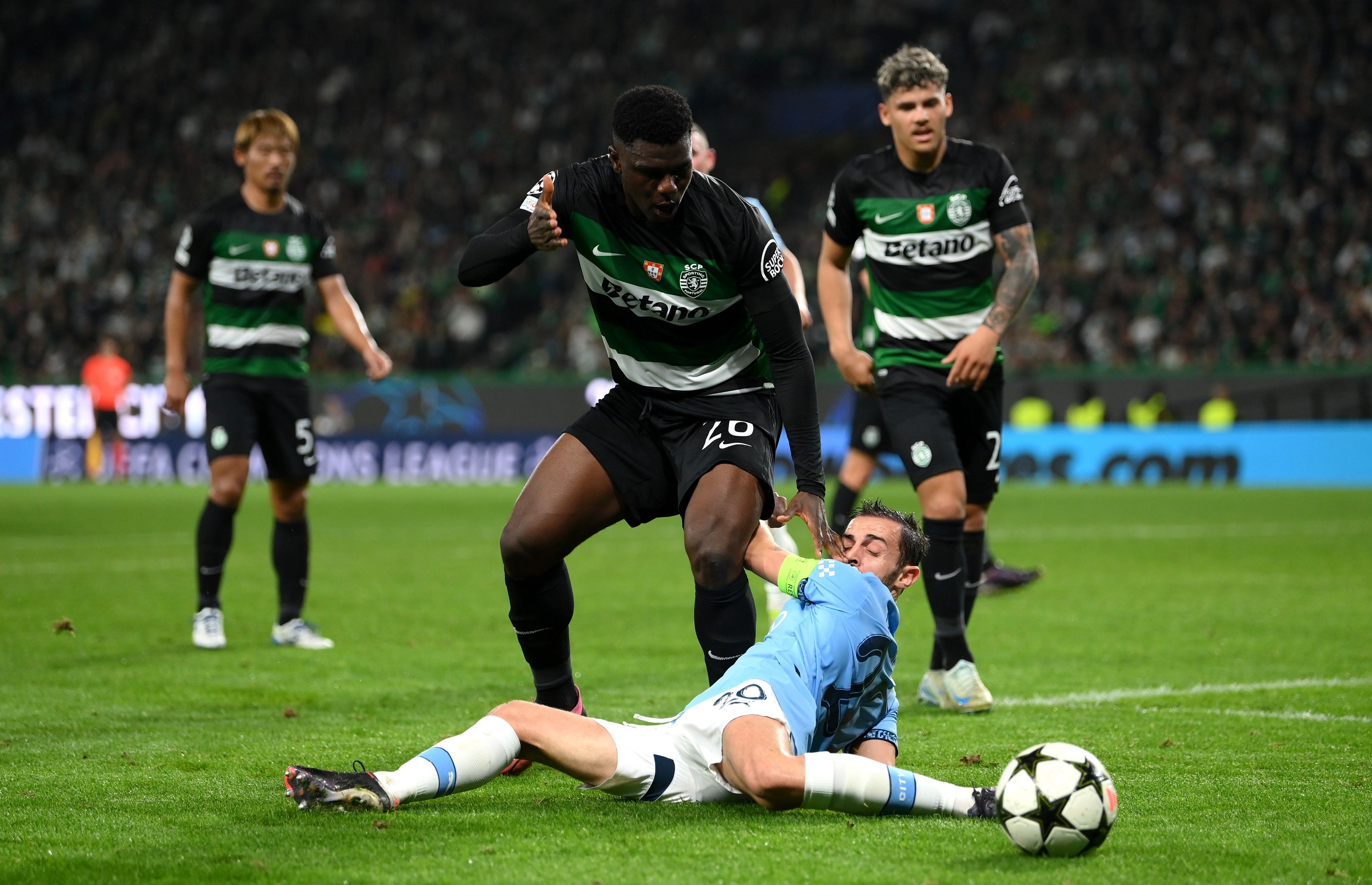 Bernardo Silva of Manchester City goes down following a challenge by Ousmane Diomande of Sporting