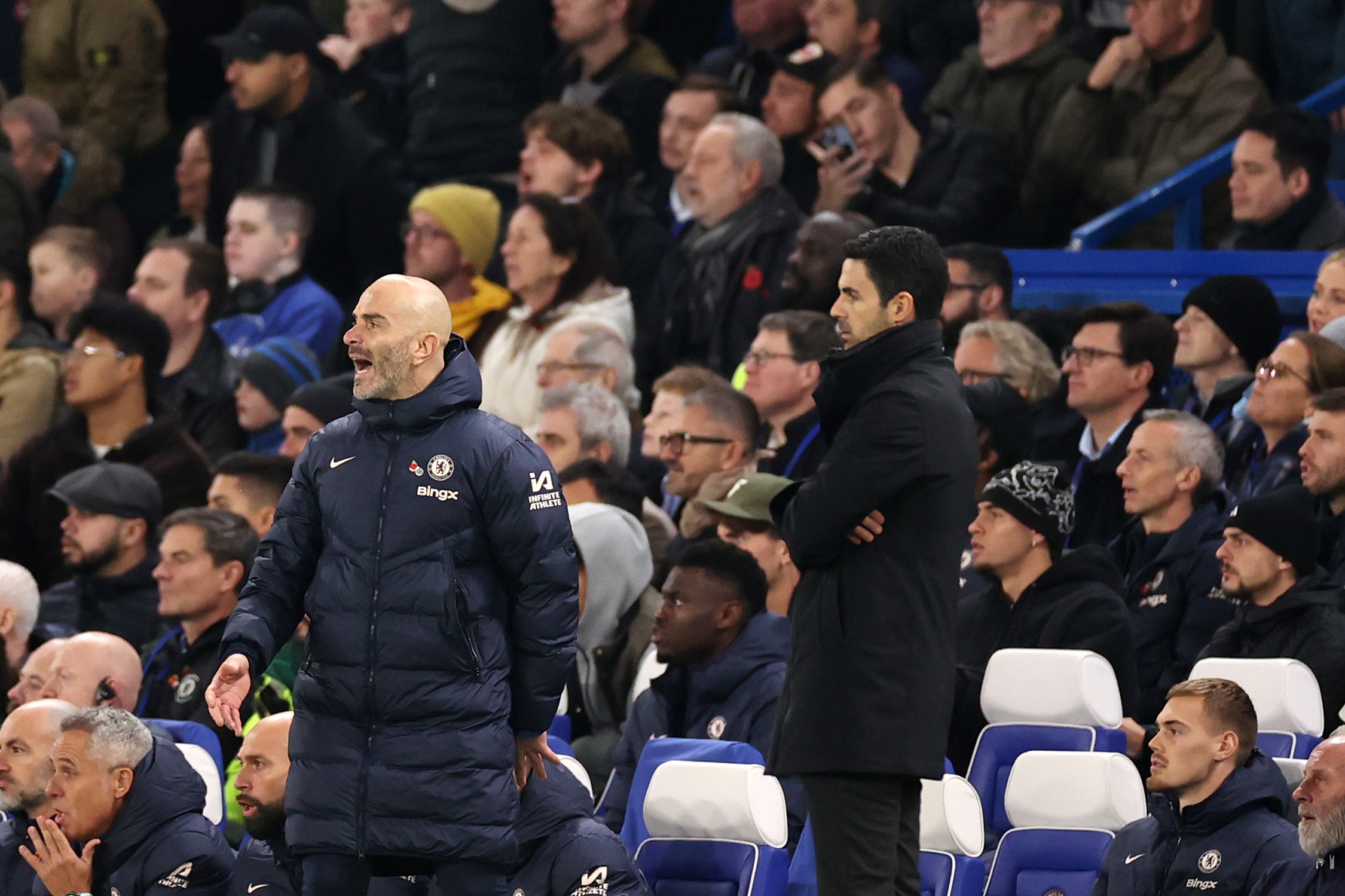 Enzo Maresca, Manager of Chelsea, reacts alongside Mikel Arteta, Manager of Arsenal.