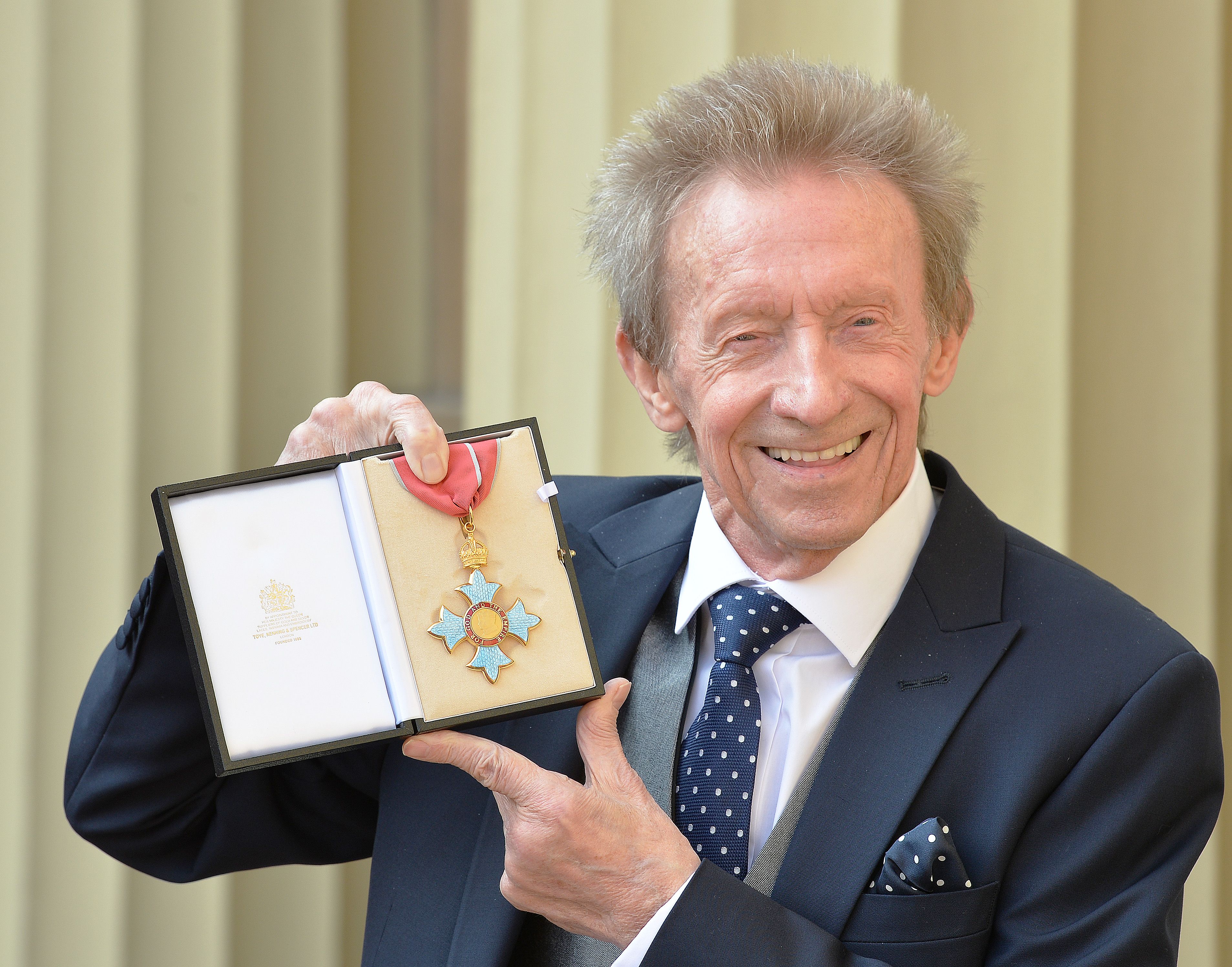 Former Scotland and Manchester United footballer Denis Law poses with his CBE.