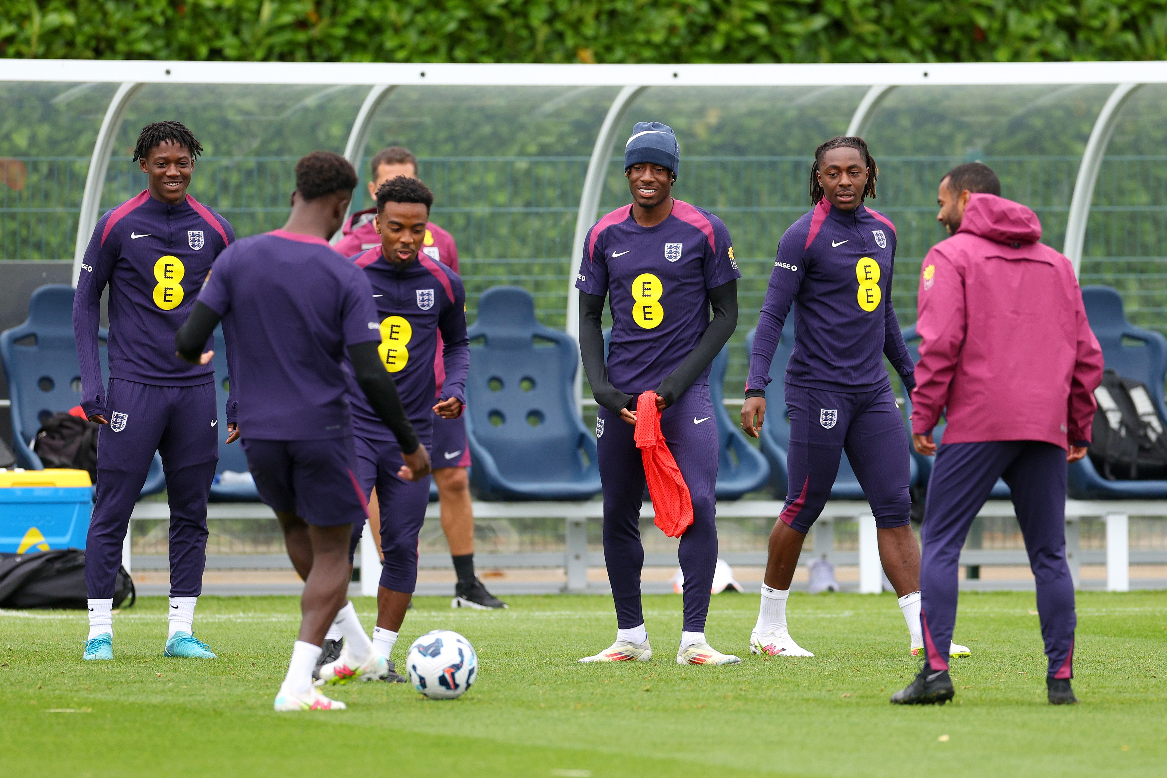 Kobbie Mainoo, Angel Gomes, Noni Madueke, Eberechi Eze and teammates look on during an England training session.