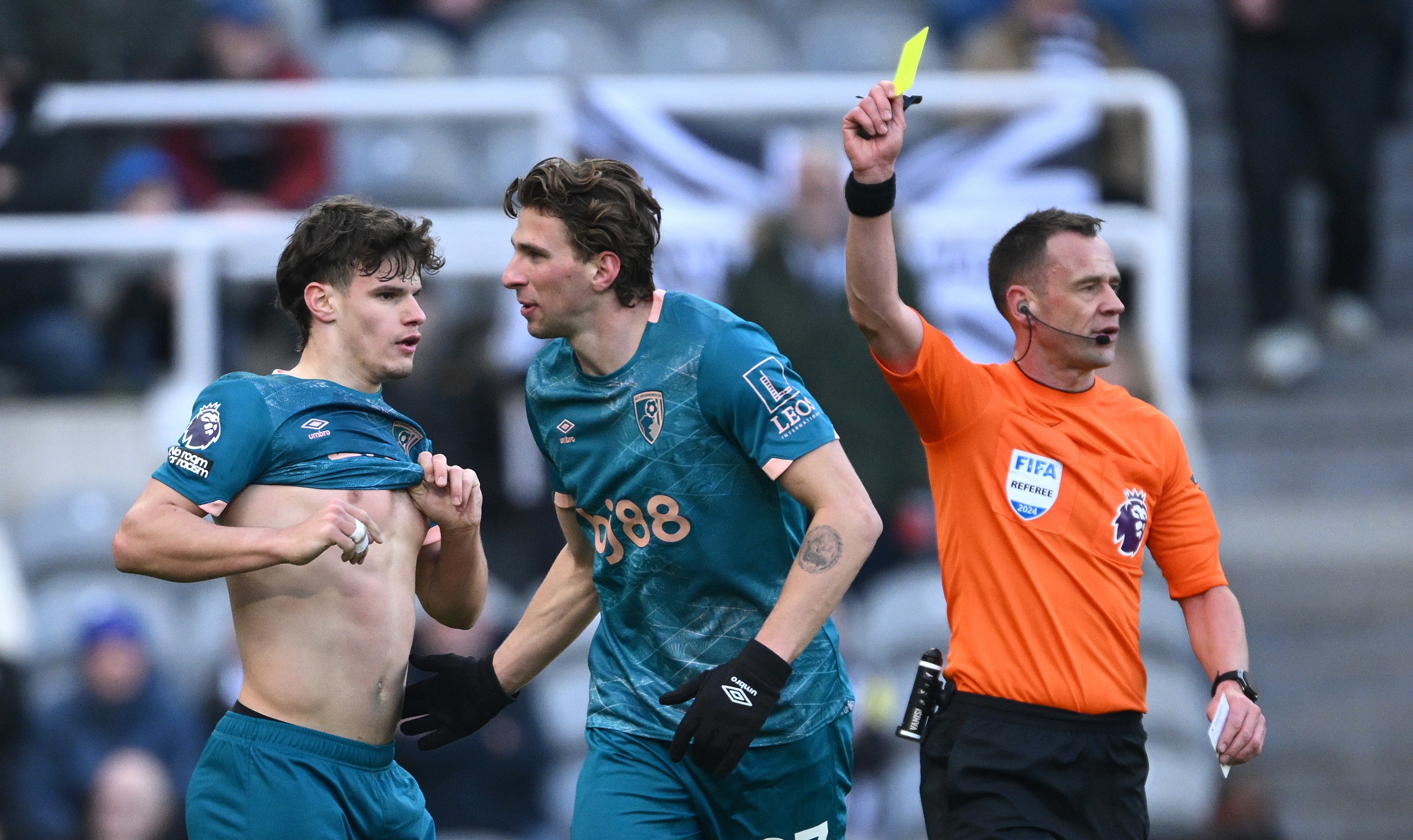 Milos Kerkez of AFC Bournemouth is shown a yellow card by referee Stuart Attwell