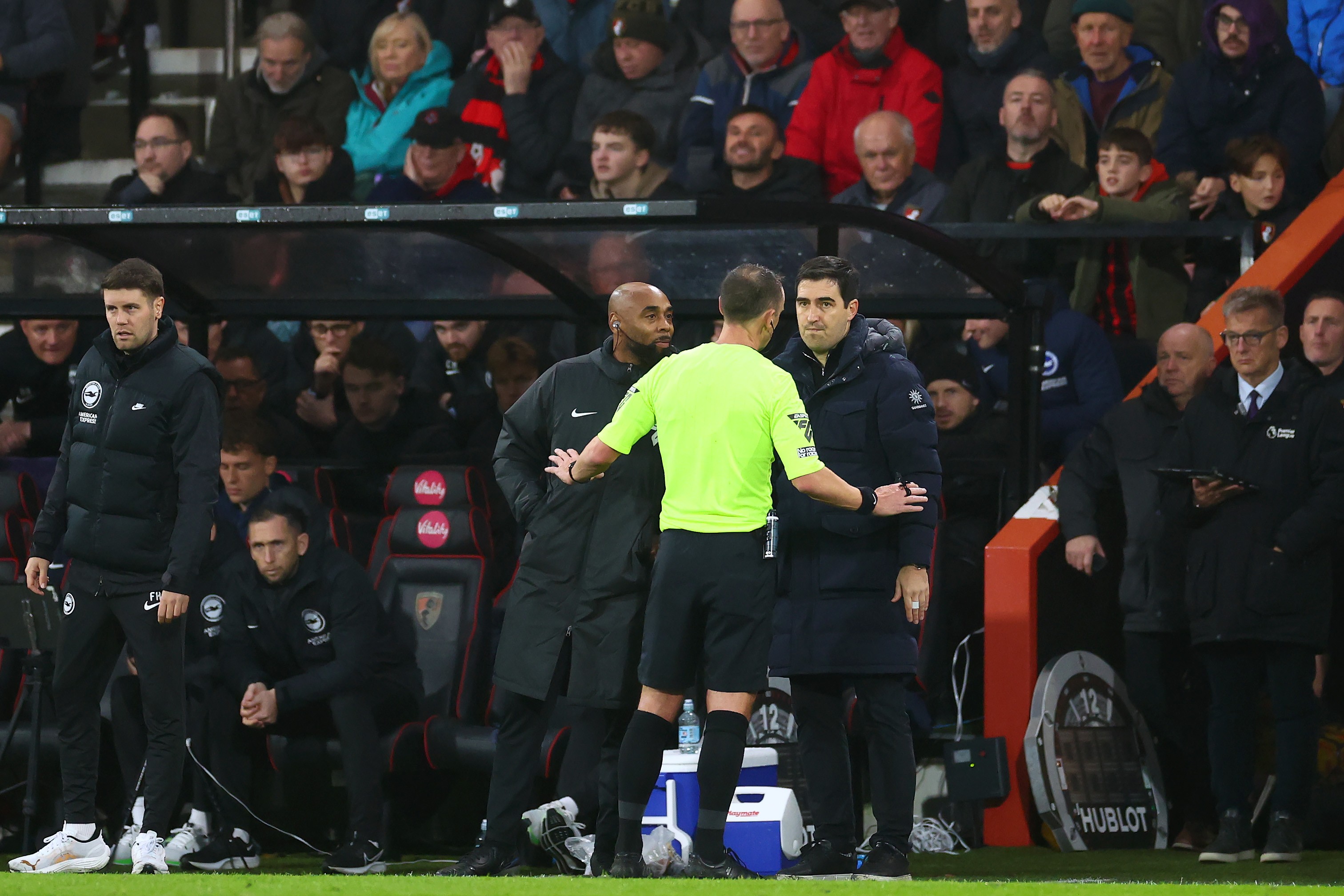Referee Stuart Attwell speaks with AFC Bournemouth manager, Andoni Iraola