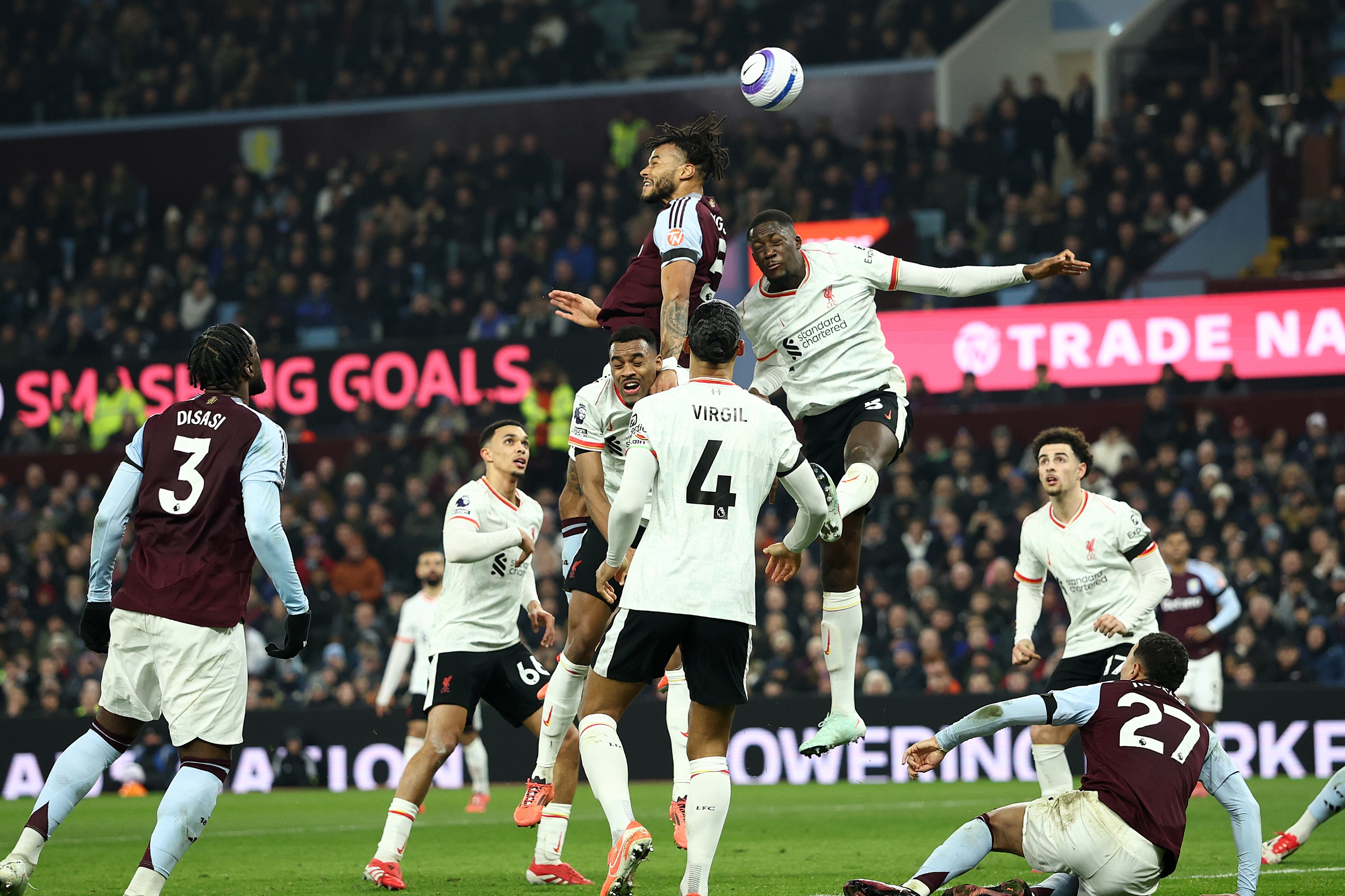 Tyrone Mings of Aston Villa heads the ball during the Premier League match against Liverpool