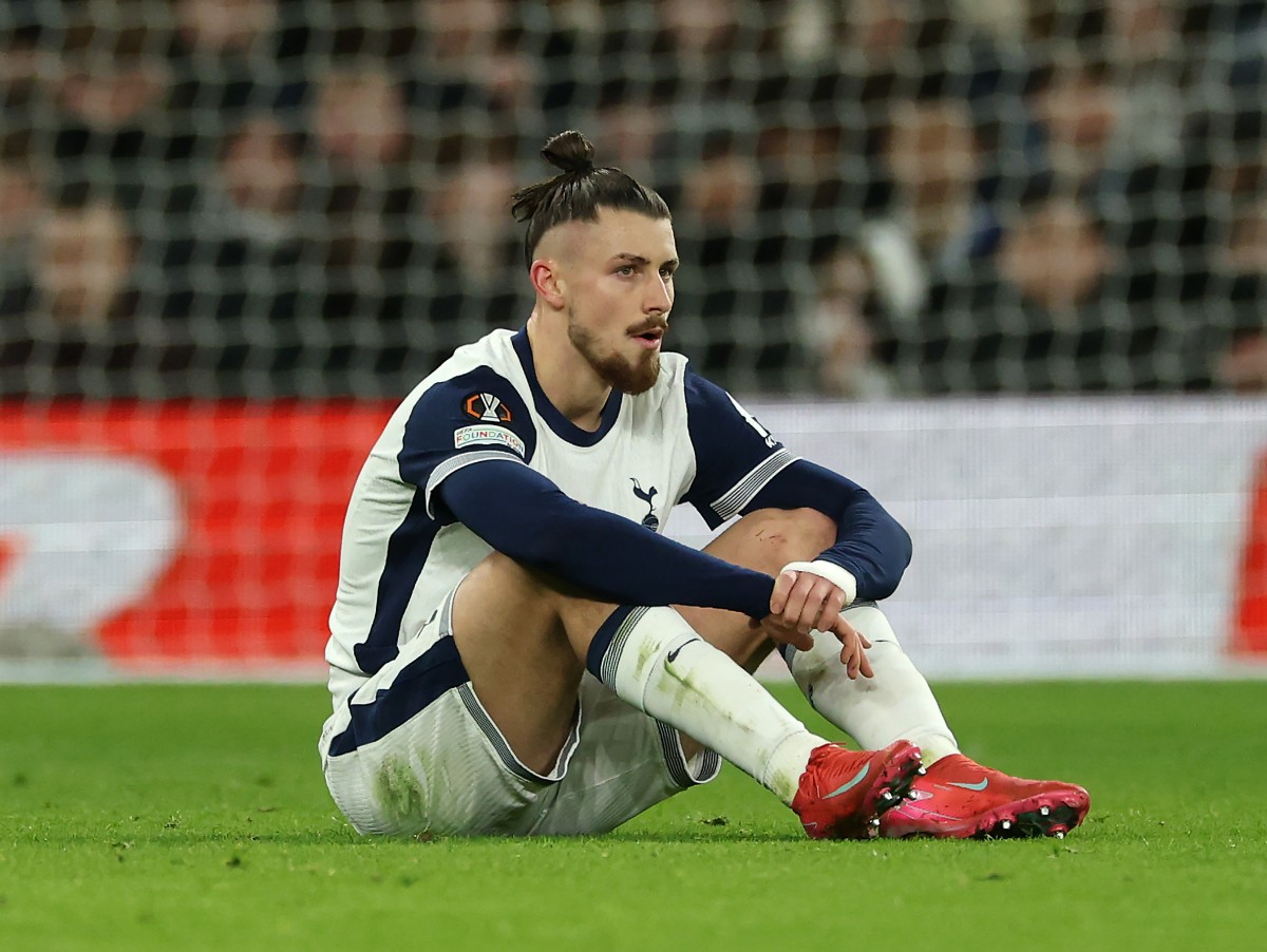 Tottenham's Radu Dragusin looks dejected after sustaining an injury