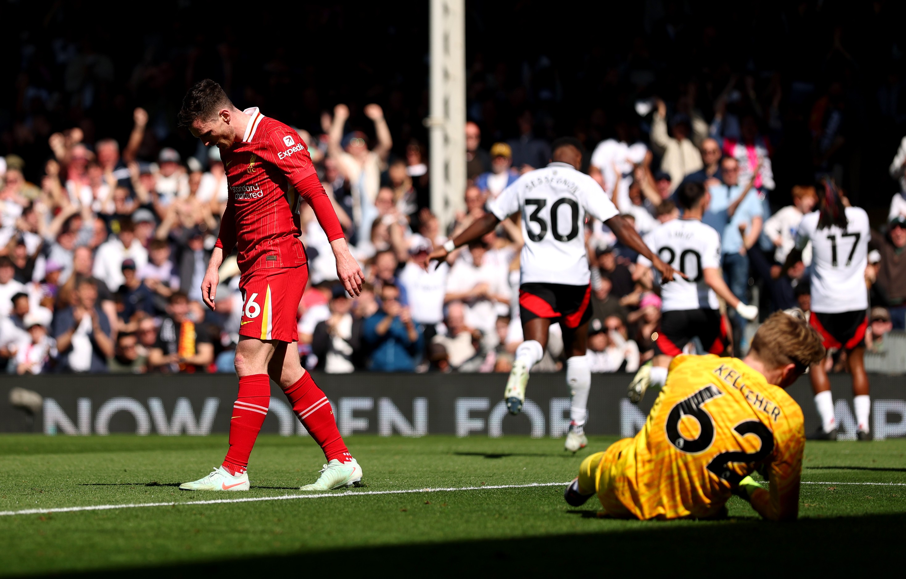 Andrew Robertson of Liverpool looks dejected after Alex Iwobi of Fulham scores