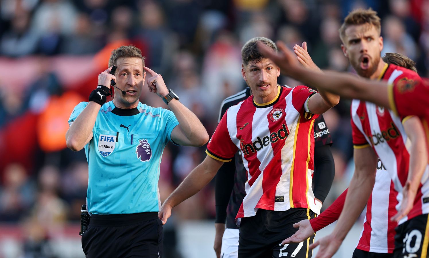 BRENTFORD, ENGLAND - OCTOBER 17: Referee John Brooks gestures to his head before showing a red card to Yehor Yarmolyuk of Brentford (not pictured) after clashing with Jeremy Jacquet of Liverpool (not pictured) during the Premier League 2026/27 match between Brentford and Liverpool FC at Gtech Community Stadium on October 17, 2026 in Brentford, England.