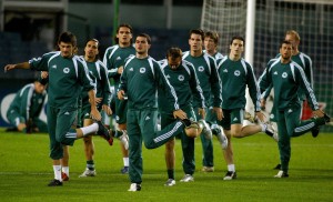 Panathanaikos players stretch during a t