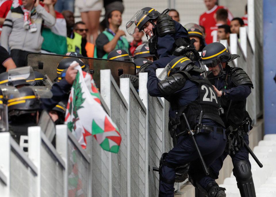 French riot police officers climb over the fence prior to the Euro 2016 Group F soccer match between Iceland and Hungary at the Velodrome stadium in Marseille, France, Saturday, June 18, 2016. Hungarian fans have clashed with stewards ahead of their team's game against Iceland at the European Championship. (AP Photo/Ariel Schalit)