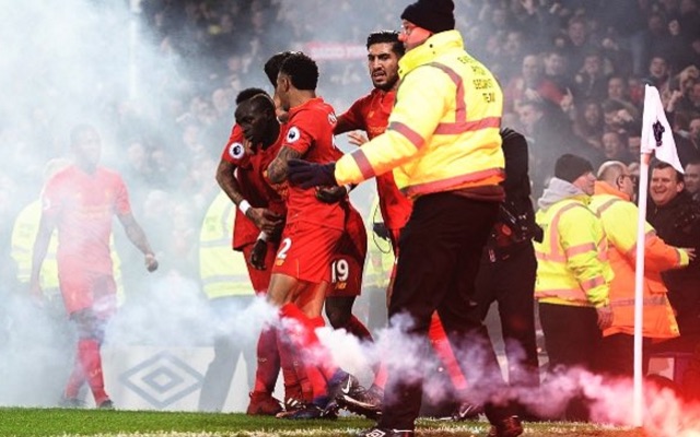 Liverpool celebrate win at Everton next to flare