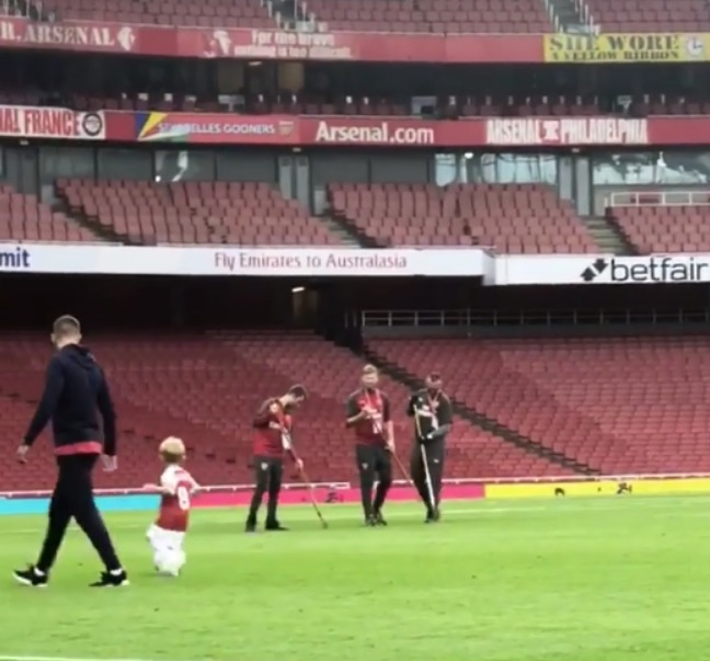 Aaron Ramsey (left) watches as his son plays on the Emirates pitch