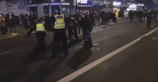 Police attend to prone man on street outside Tottenham Hotspur Stadium