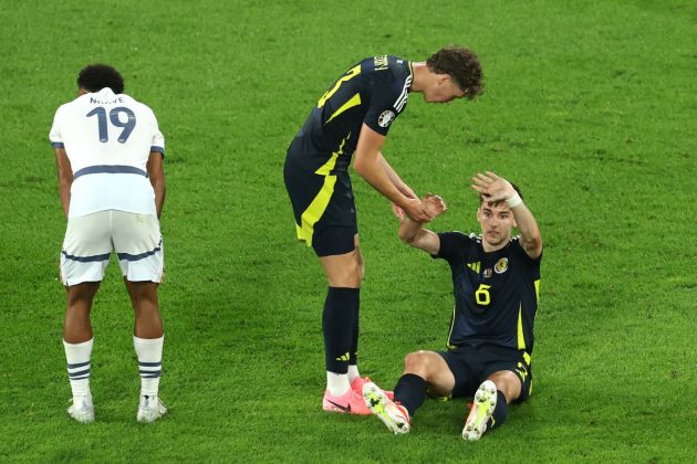 Kieran Tierney of Scotland calls for medical assistance as he interacts with Jack Hendry of Scotland after being challenged by Dan Ndoye of Switzerland during the UEFA EURO 2024 group stage match between Scotland and Switzerland at Cologne Stadium on June 19, 2024