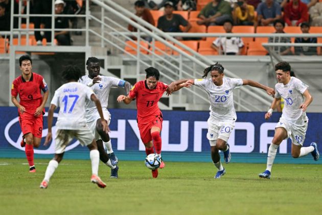 South Korea's Yang Min-hyeok (11) fights for a ball with France's Mathis Amougou (20) and Ismail Bouneb (10) during the World Cup U17 qualifying group E match between France and South Korea in Jakarta on November 15, 2023.