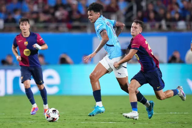 Nico O'Reilly #75 of Manchester City dribbles the ball against Marc Casadó #30 of FC Barcelona in the second half during a pre-season match between Manchester City and FC Barcelona at Camping World Stadium on July 30, 2024 in Orlando, Florida.