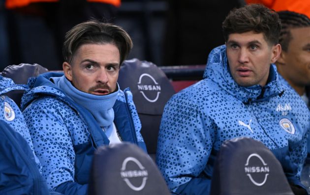 Manchester City substitutes Jack Grealish and John Stones (r) look on from the bench during the Emirates FA Cup Quarter Final match between Manchester City and Newcastle United at Etihad Stadium on March 16, 2024 in Manchester, England.