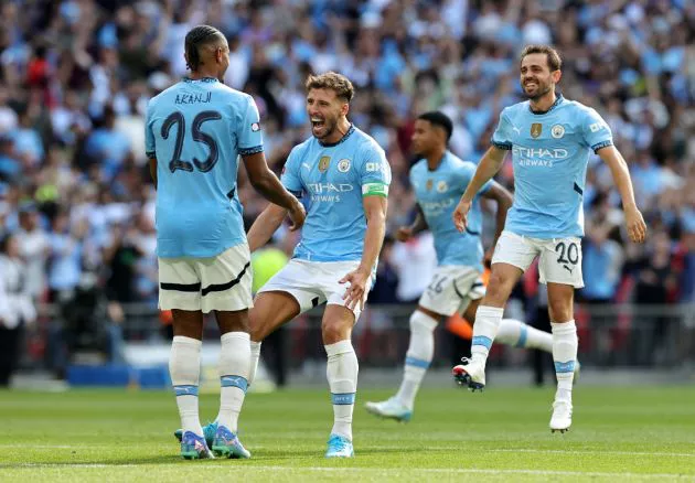 Manuel Akanji of Manchester City celebrates with teammates Ruben Dias and Bernardo Silva of Manchester City after scoring the winning penalty in the shoot-out during the 2024 FA Community Shield match between Manchester United and Manchester City at Wembley Stadium on August 10, 2024 in London, England.