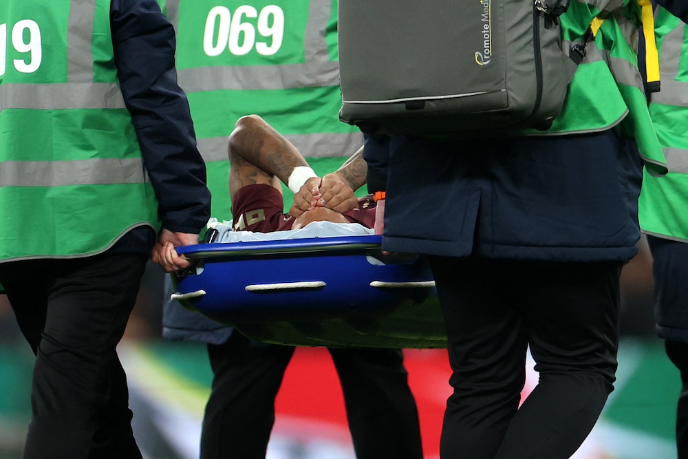 Savinho being stretchered off the pitch during Tottenham vs. Man City after injuring his ankle.