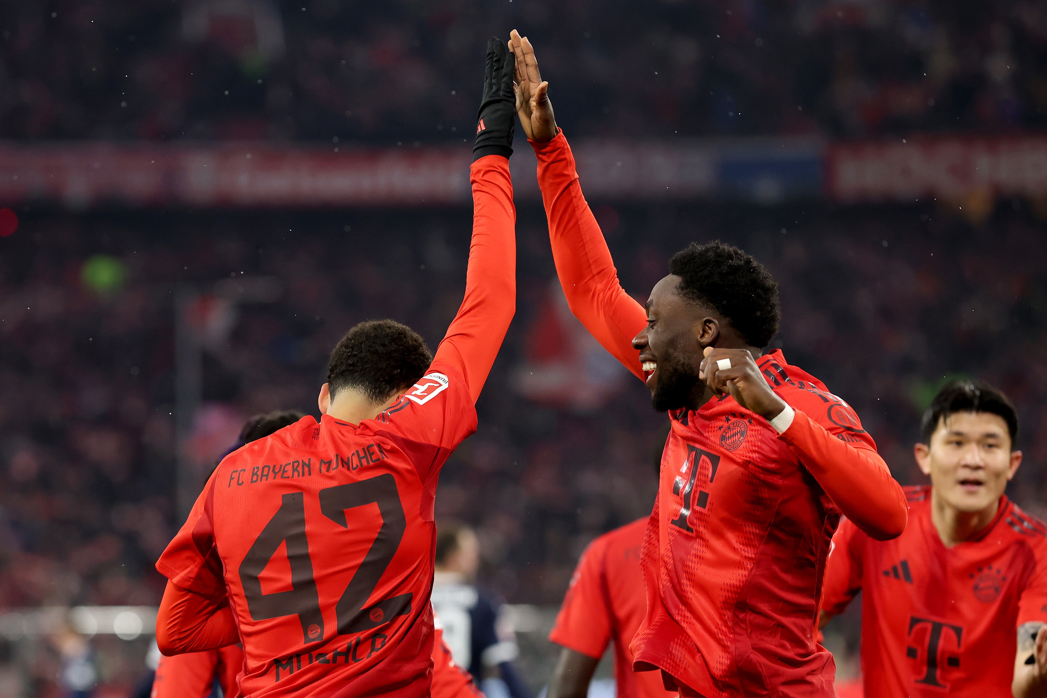 Alphonso Davies celebrates Jamal Musiala's goal for Bayern Munich.