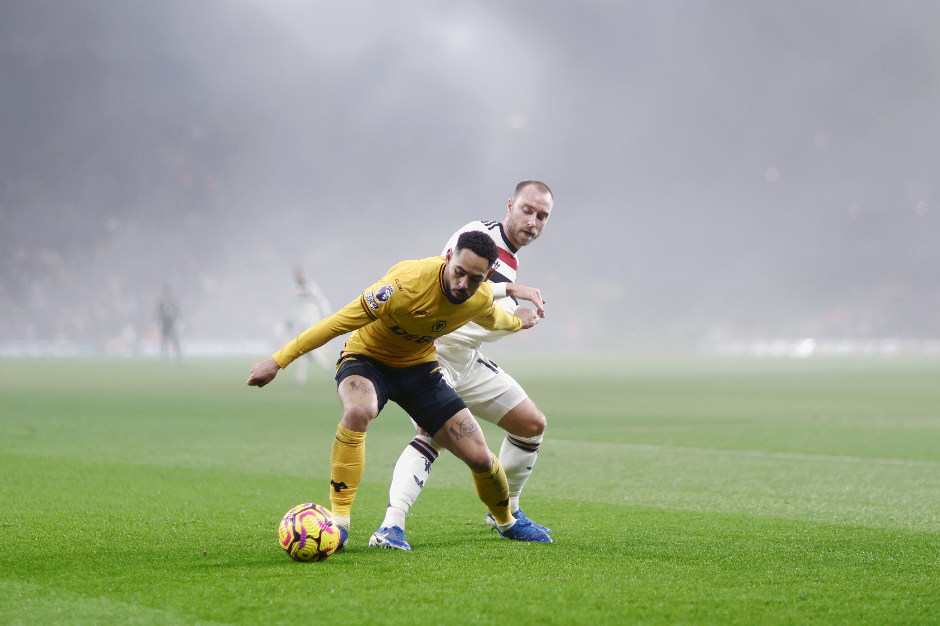 Matheus Cunha of Wolverhampton Wanderers fights for the ball with Christian Eriksen of Manchester United 