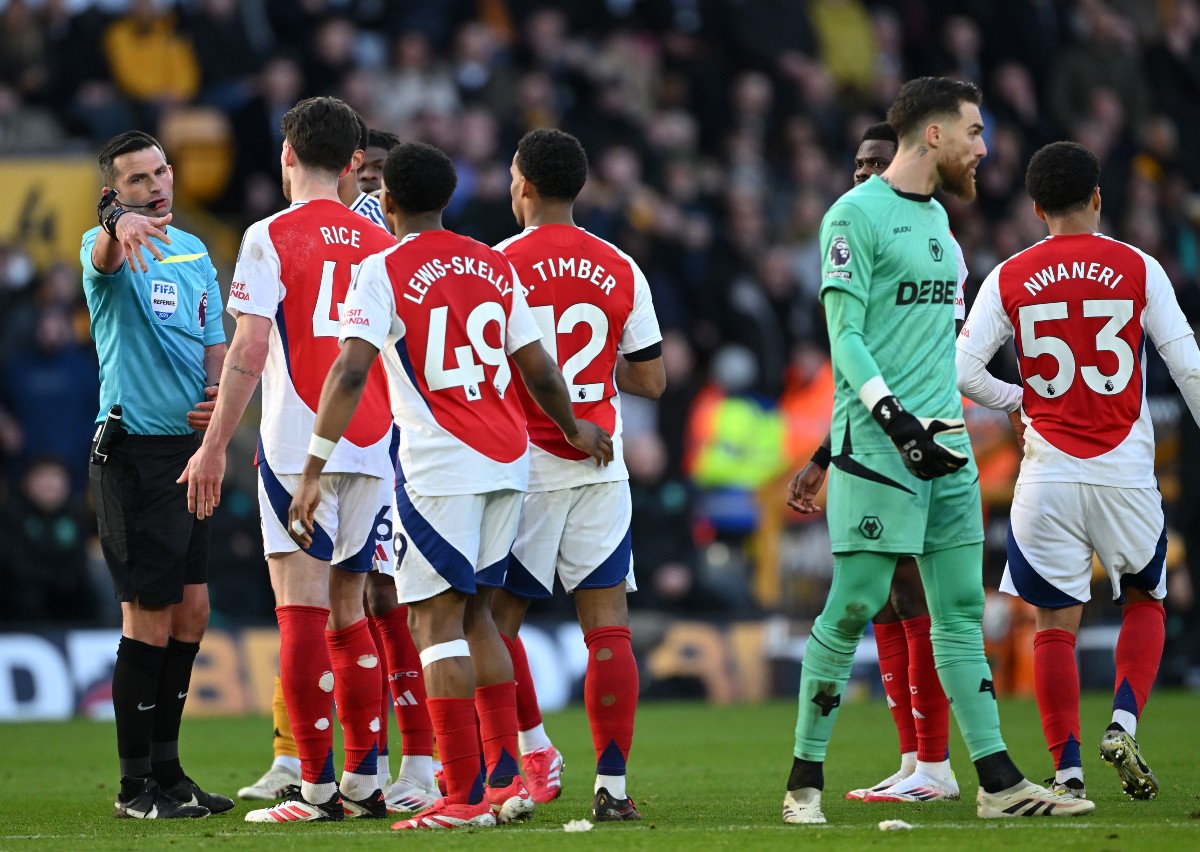 Michael Oliver is confronted by Arsenal players