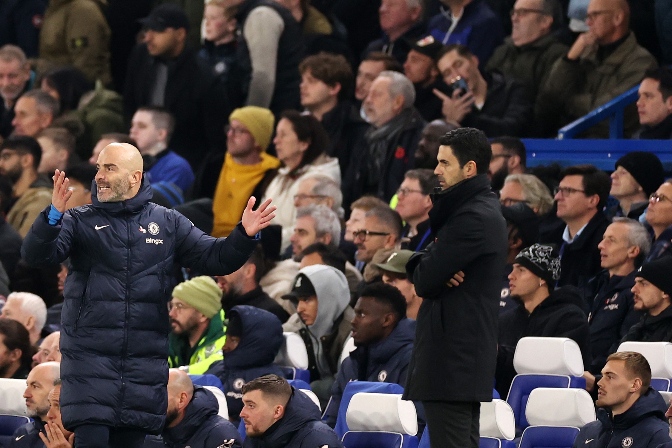 Enzo Maresca, Manager of Chelsea, reacts alongside Mikel Arteta, Manager of Arsenal