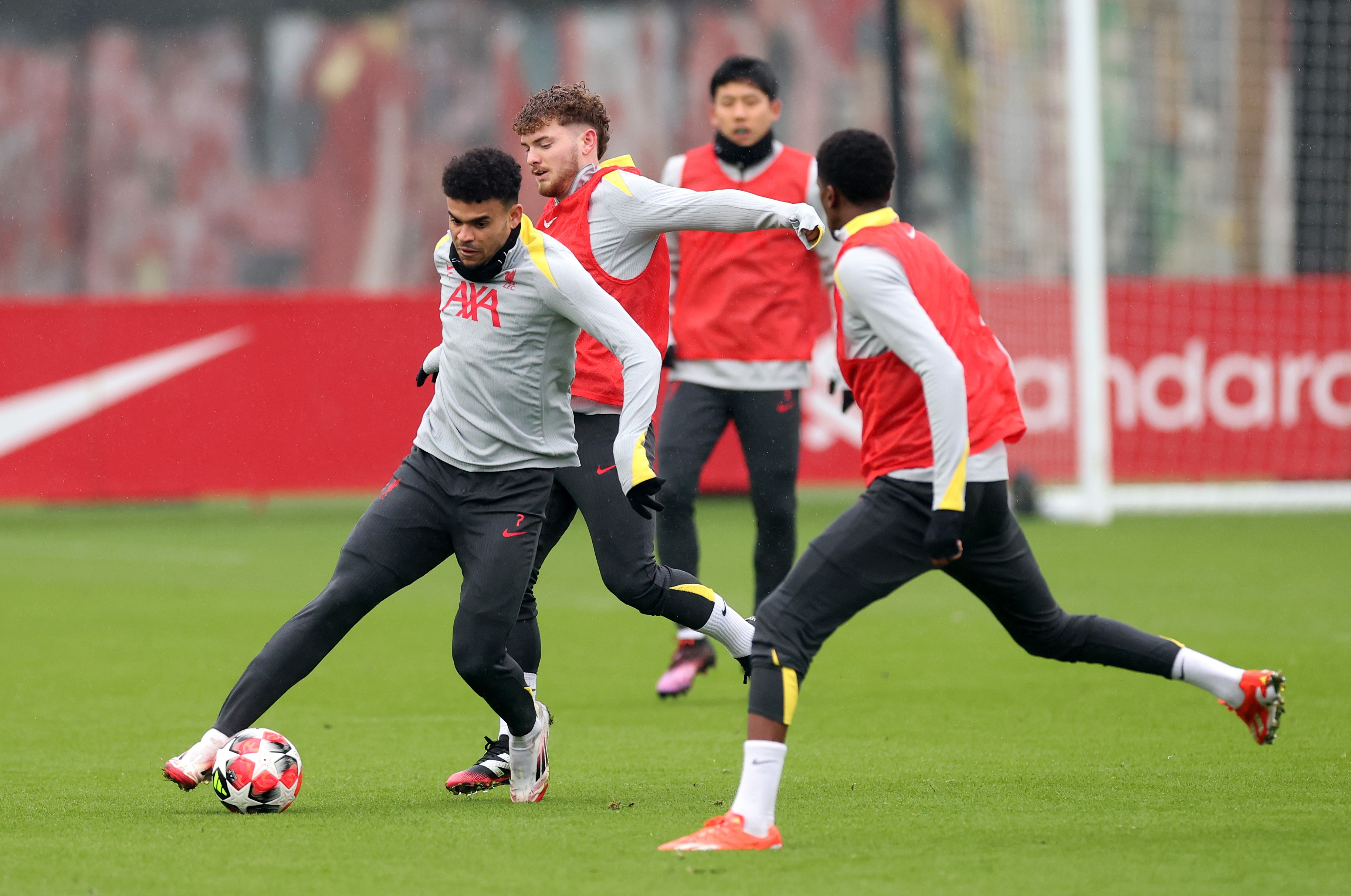 Liverpool's Luis Diaz controls the ball under pressure from his teammate Harvey Elliott.