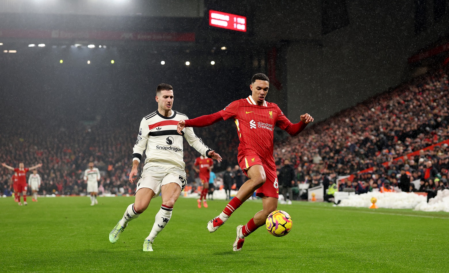 Liverpool's Trent Alexander-Arnold is challenged by Manchester United's Diogo Dalot