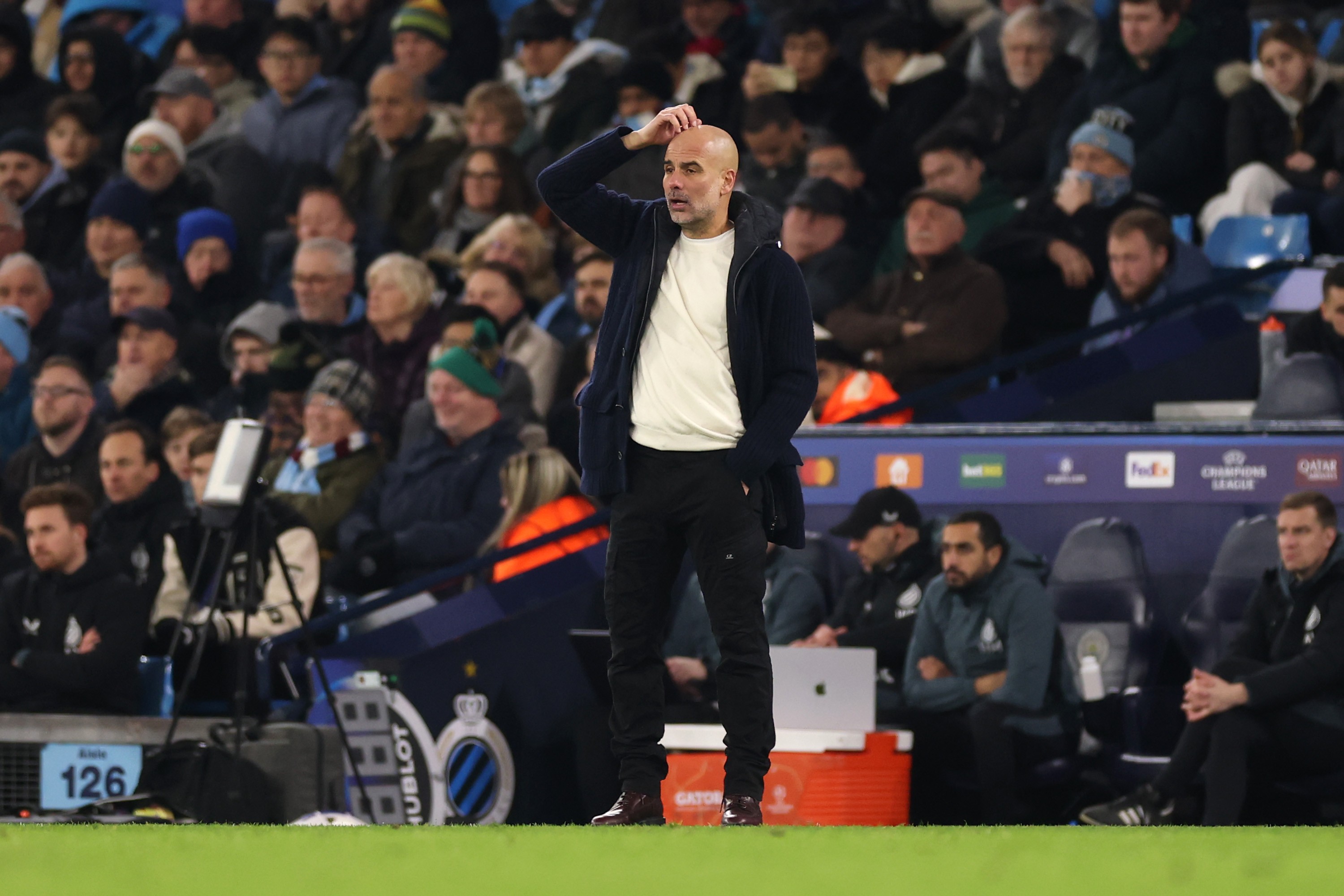 Pep Guardiola, Manager of Manchester City, scratches his head 