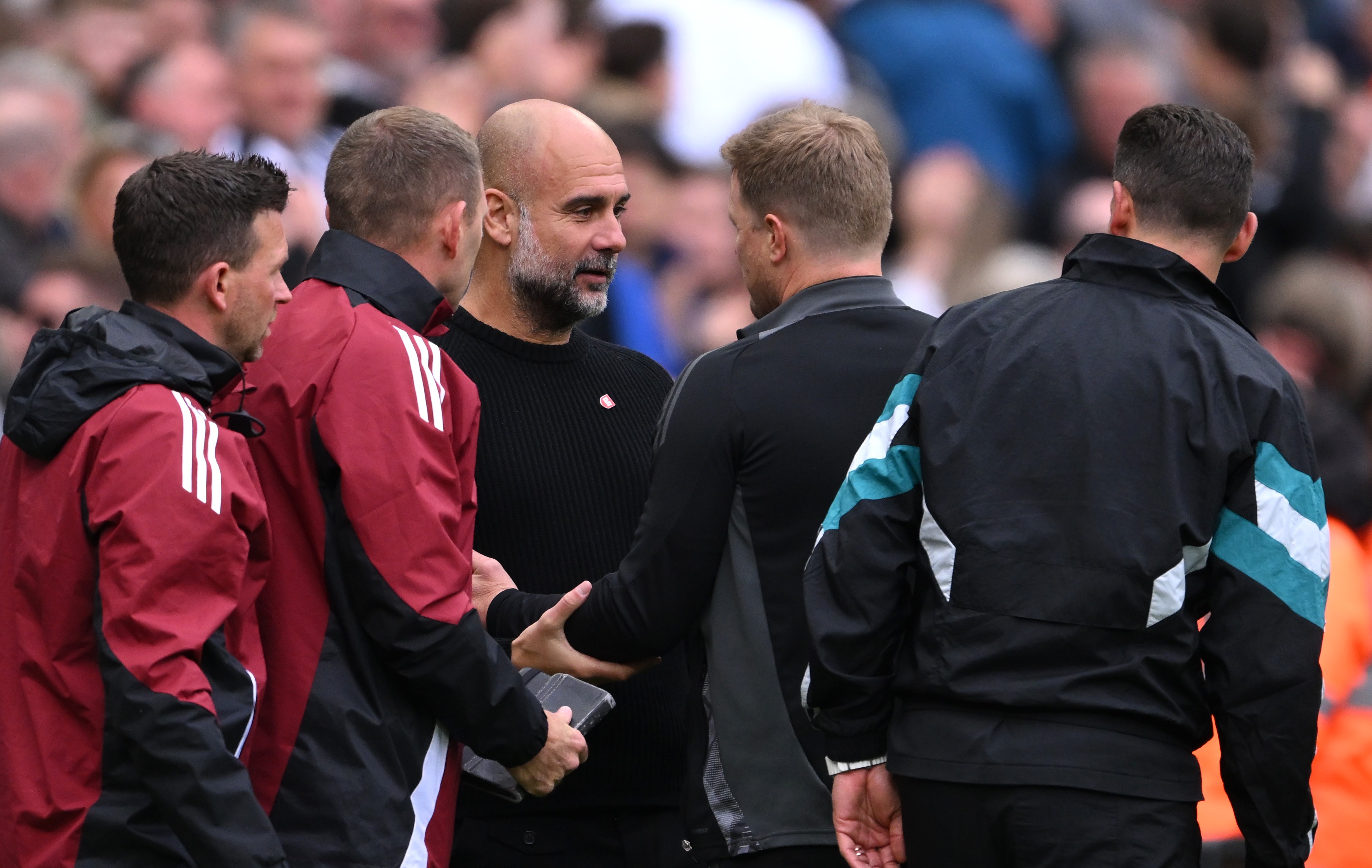 Pep Guardiola, manager of Manchester City, interacts with Eddie Howe, manager of Newcastle United