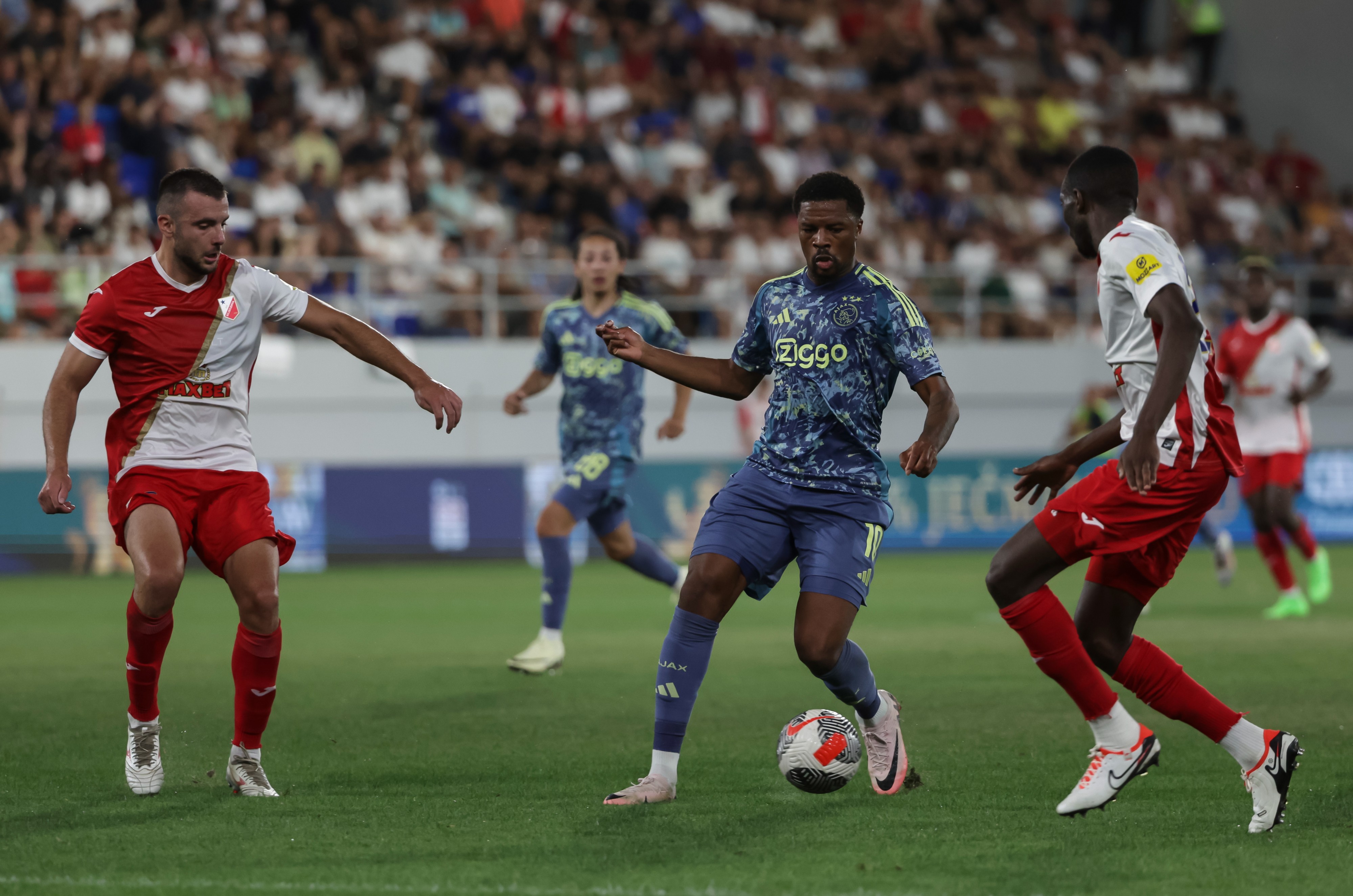 Chuba Akpom of Ajax in action against Djordje Crnomarkovic and Collins Sichenje of Vojvodina 