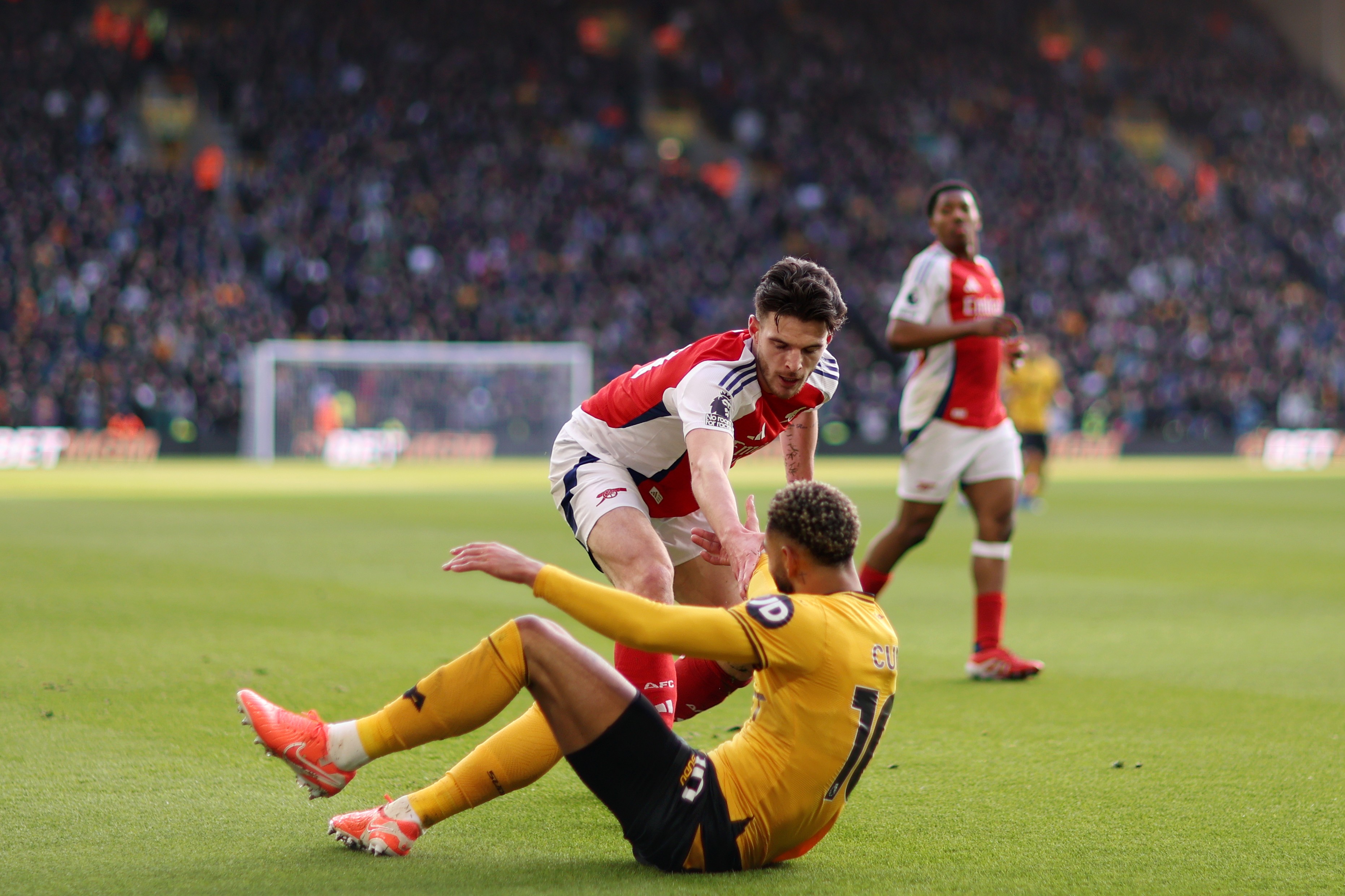 Declan Rice of Arsenal helps up Matheus Cunha of Wolves