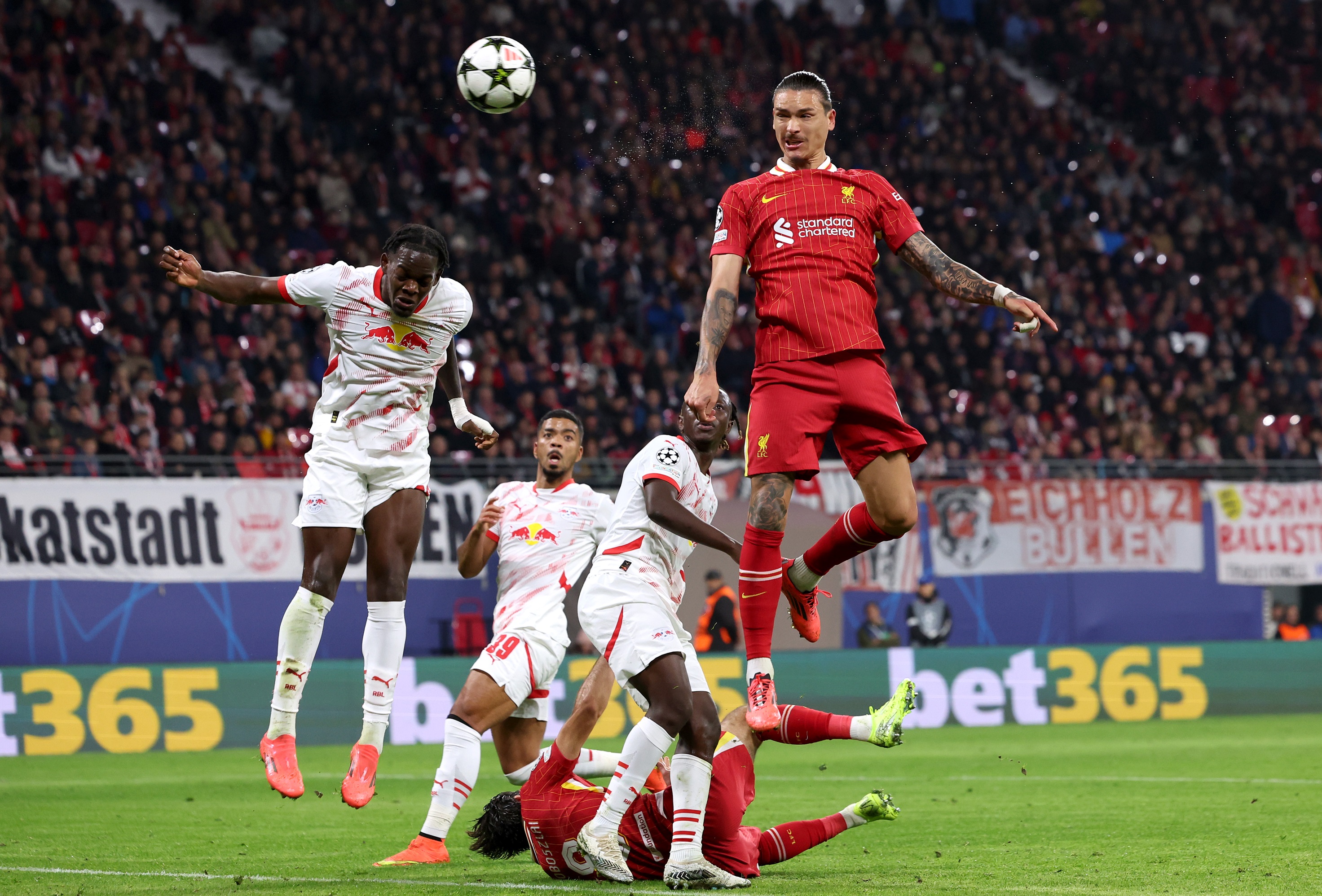 Castello Lukeba jumps for a ball with Liverpool striker Darwin Nunez.