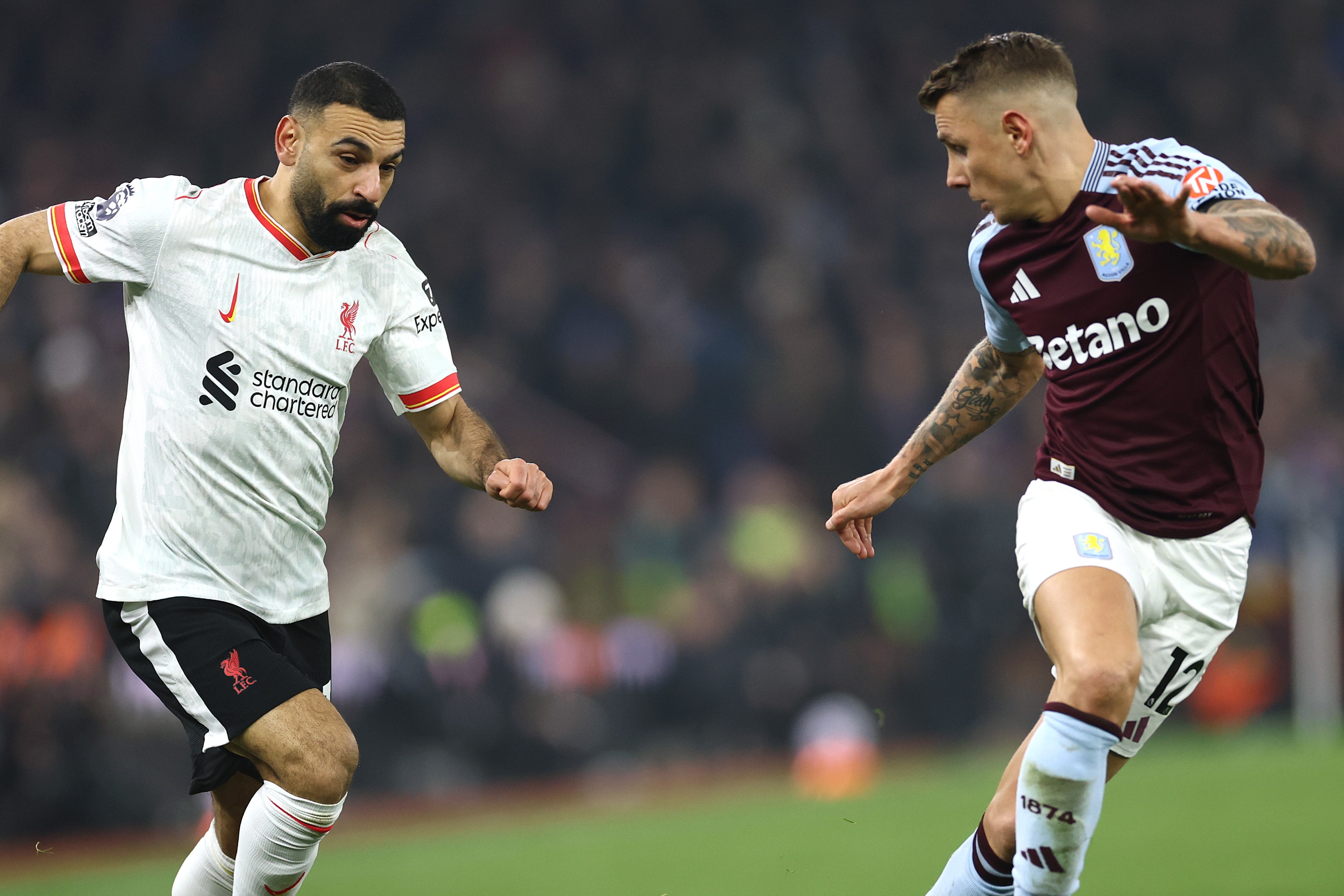 Mohamed Salah of Liverpool runs with the ball under pressure from Lucas Digne of Aston Villa