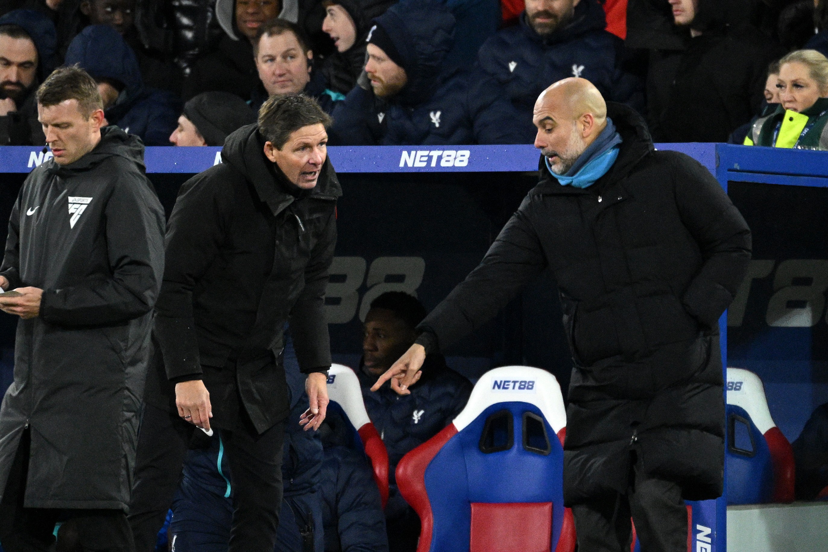 Pep Guardiola, Manager of Manchester City, points at the fourth officials foot as Oliver Glasner, Manager of Crystal Palace looks on.