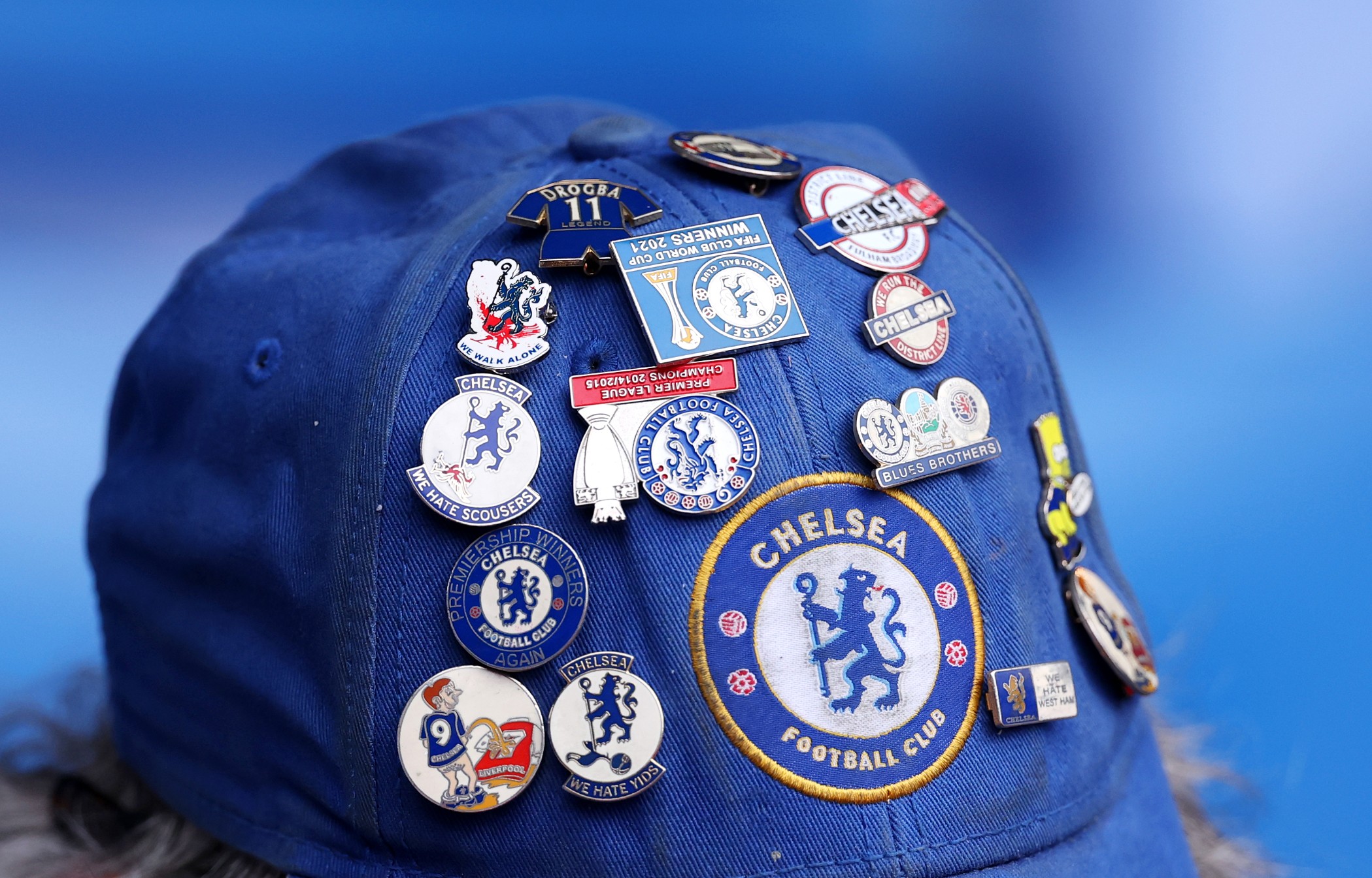 Pin badges are seen on the cap of a Chelsea fan