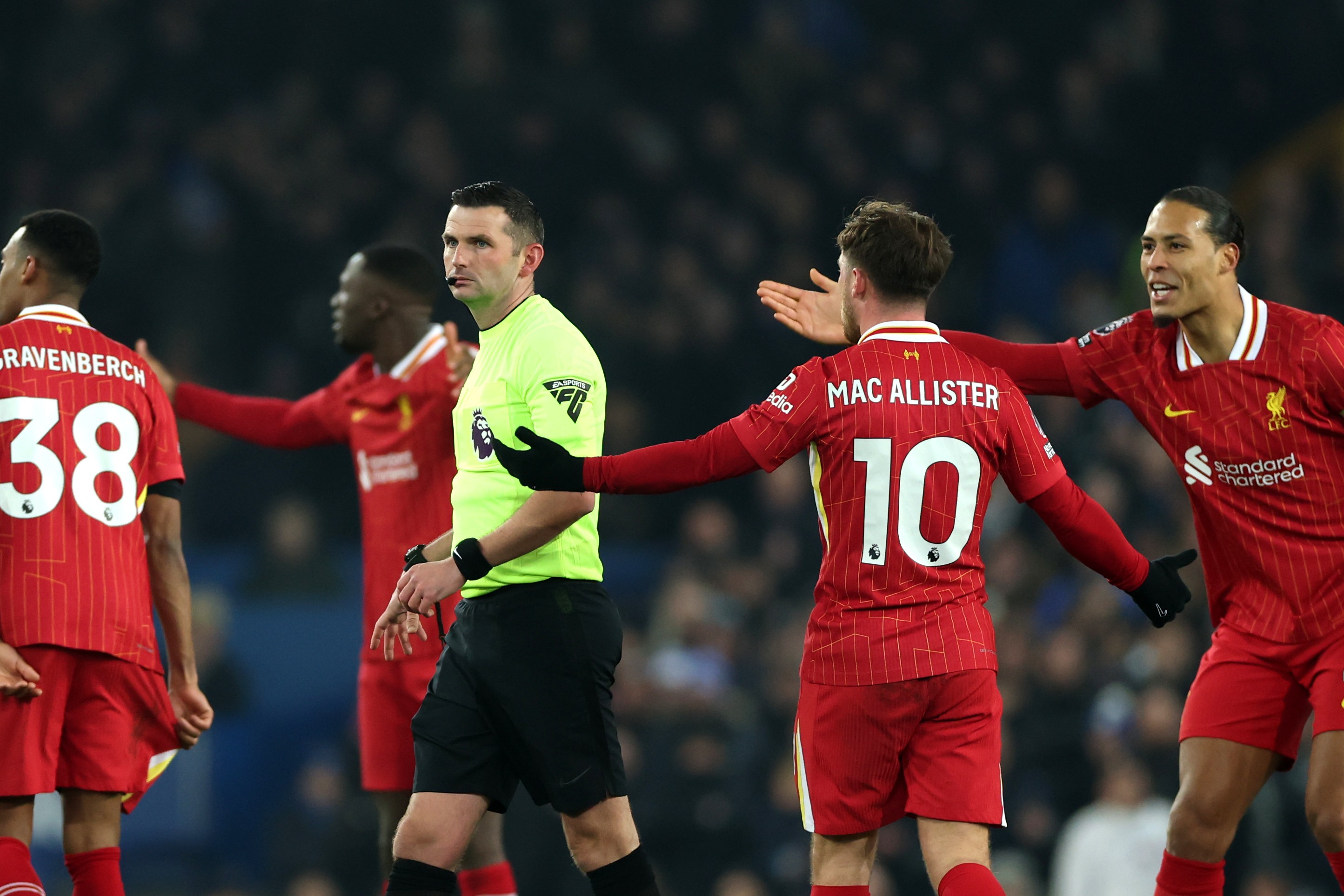 Virgil van Dijk and Alexis Mac Allister of Liverpool remonstrate with referee Michael Oliver