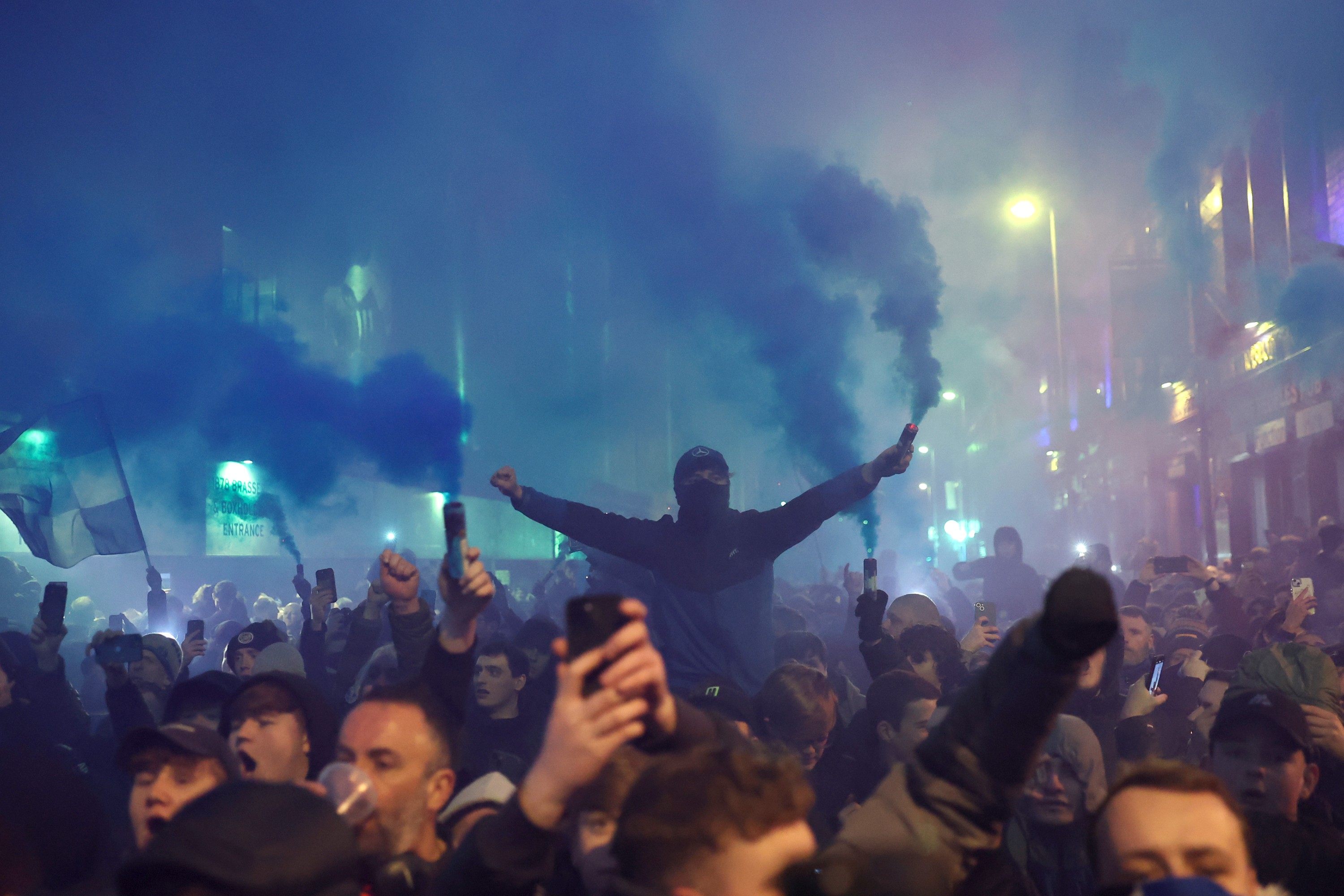 General view outside the stadium as fans of Everton are seen holding blue flares