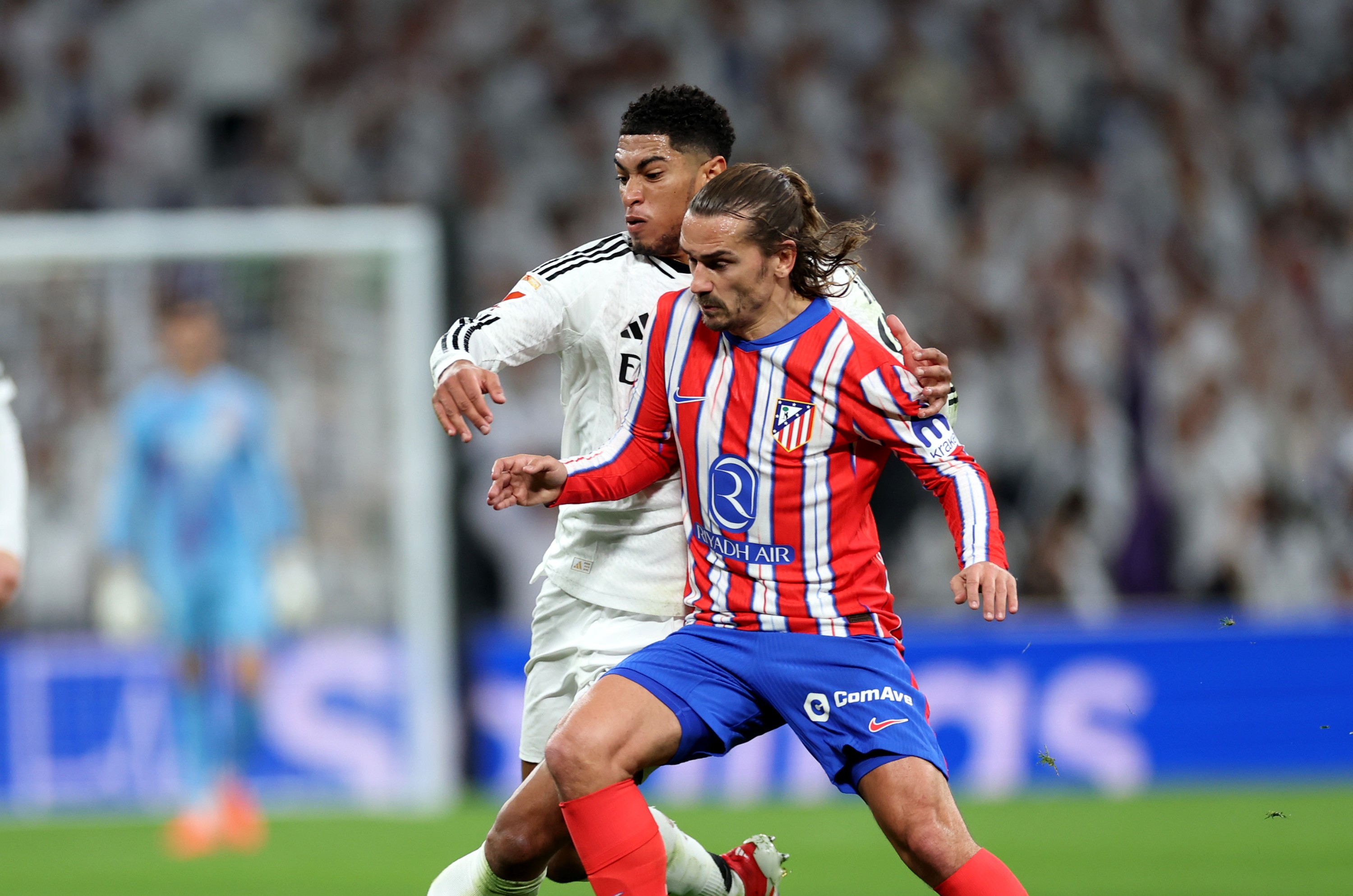 Antoine Griezmann of Atletico Madrid is challenged by Jude Bellingham of Real Madrid during the Madrid derby