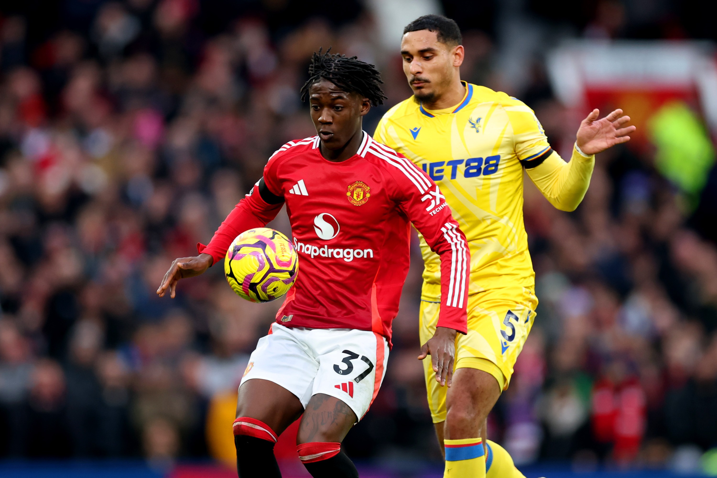 Kobbie Mainoo of Manchester United controls the ball under pressure from Maxence Lacroix 