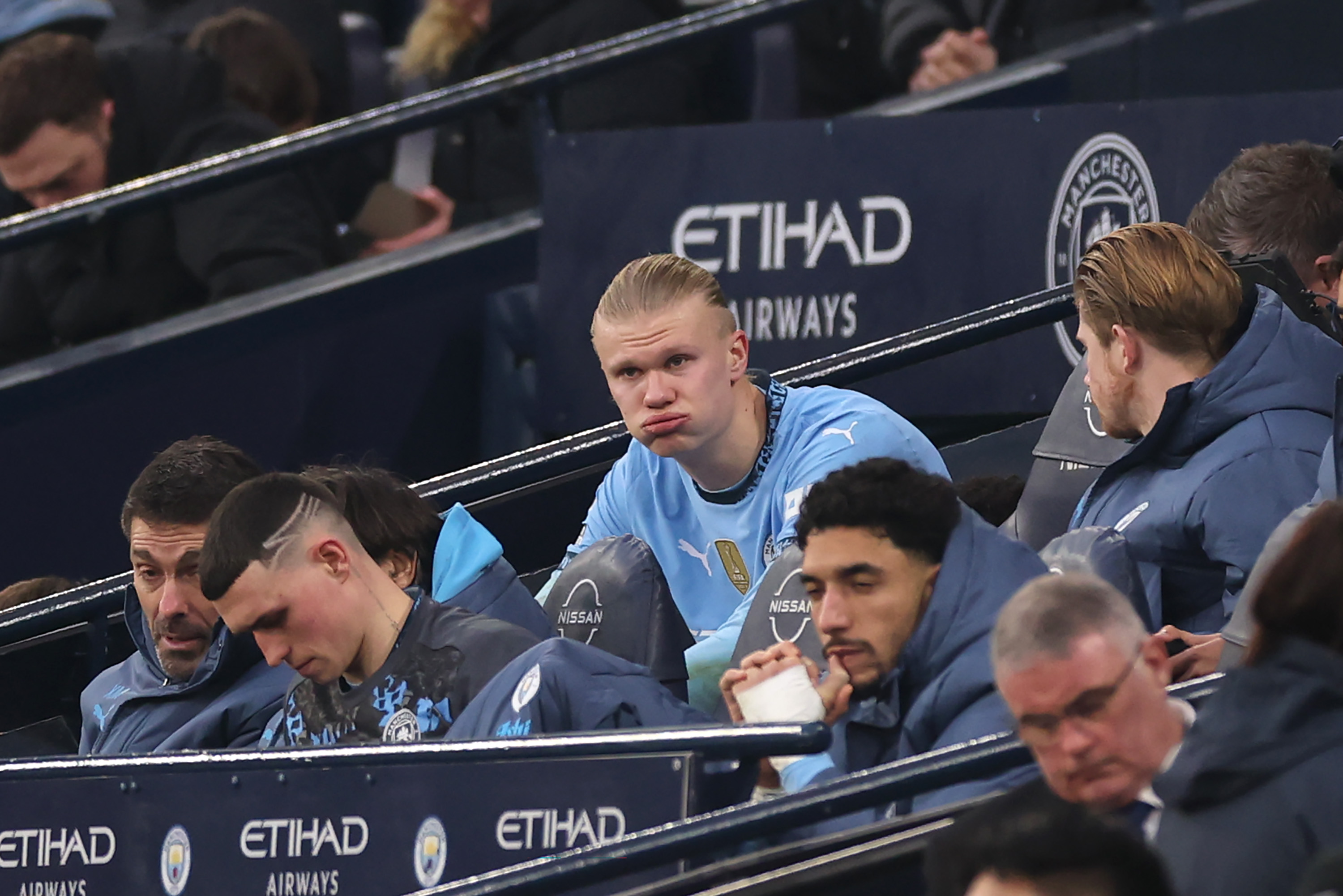 Erling Haaland of Manchester City reacts on the substitutes bench, after leaving the pitch with a injury