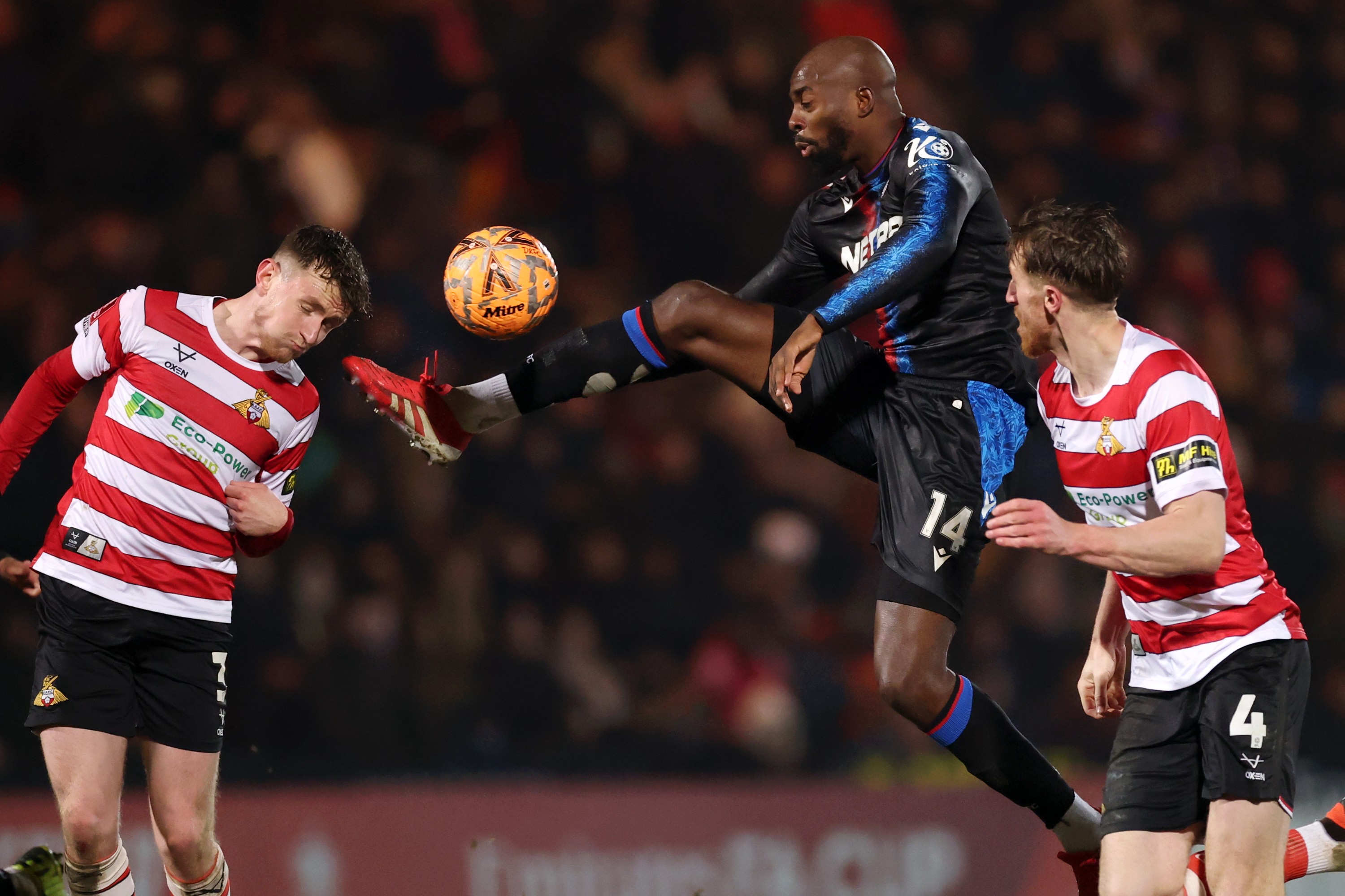 Jean-Philippe Mateta of Crystal Palace controls the ball in the air under pressure from James Maxwell of Doncaster Rovers during the Emirates FA Cup Fourth Round match