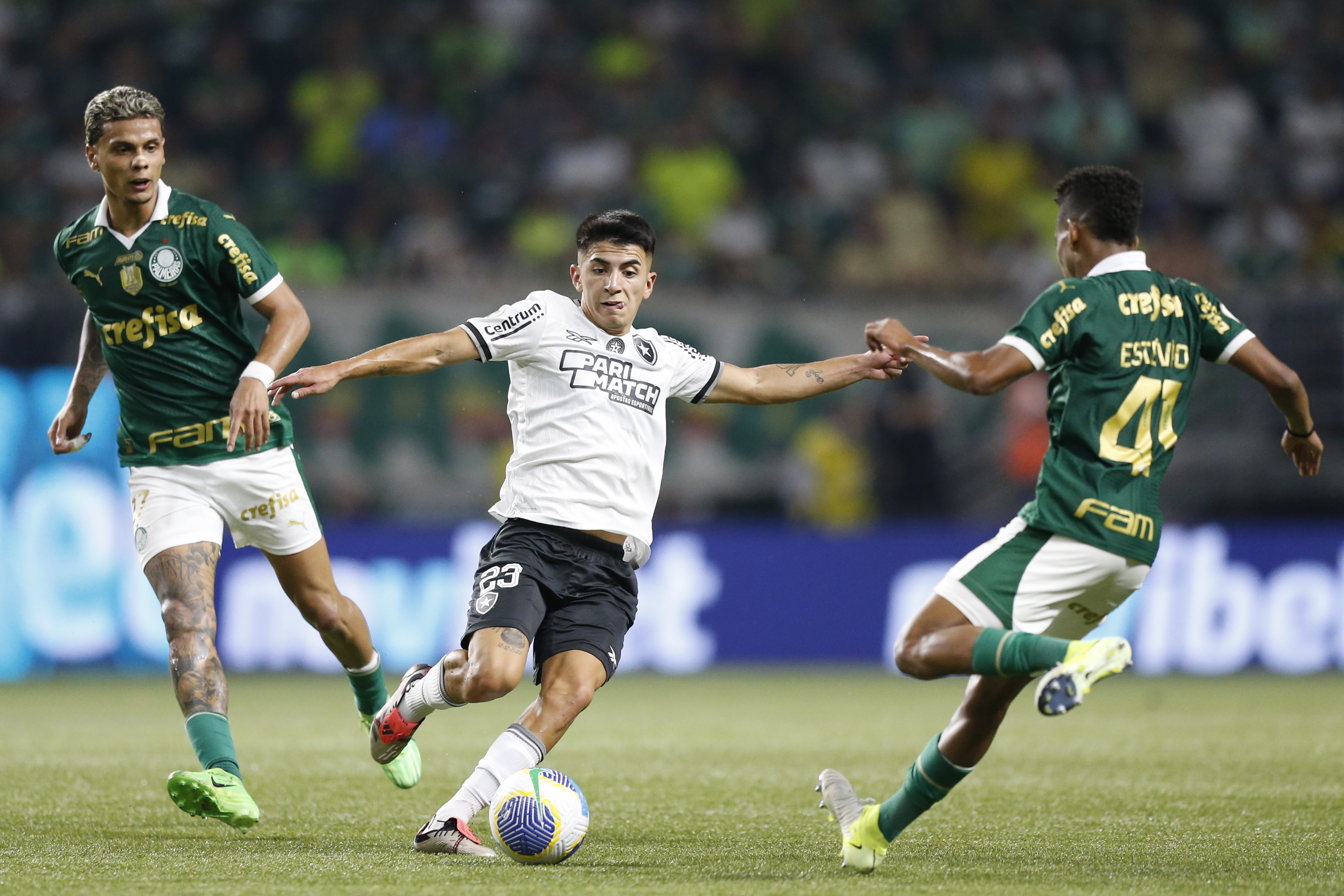 Almada (C) of Botafogo fights for the ball against Richard Rios and Estevao (R) of Palmeiras during a match on November 26, 2024 in Sao Paulo, Brazil