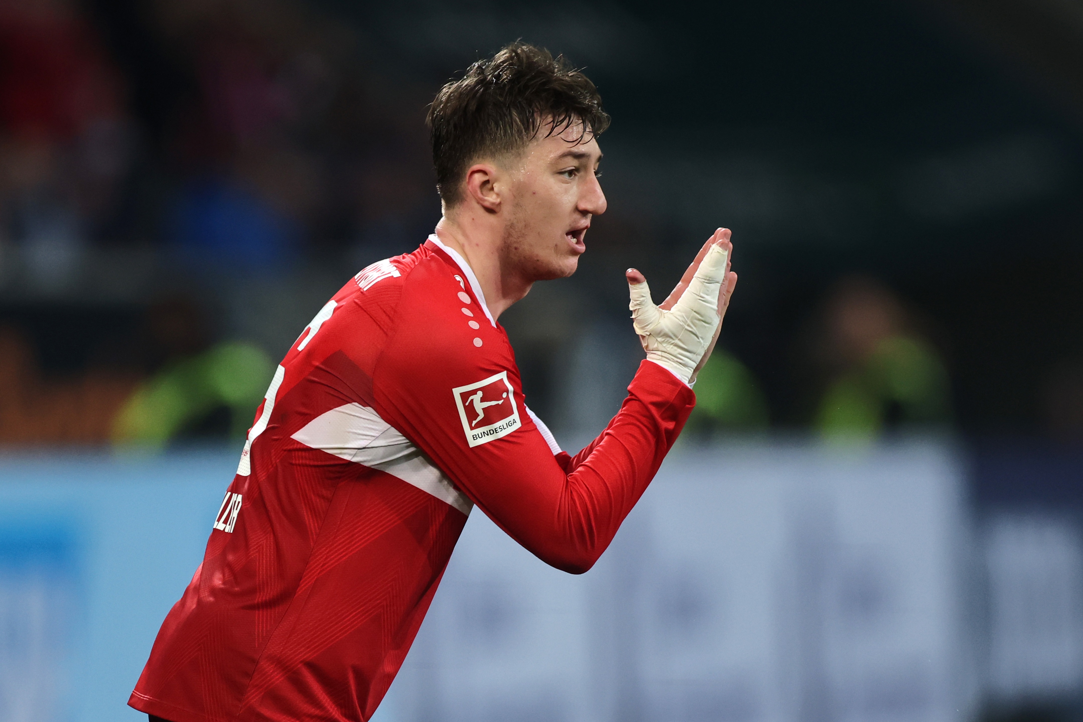 Angelo Stiller gestures with his hands during Bundesliga game.