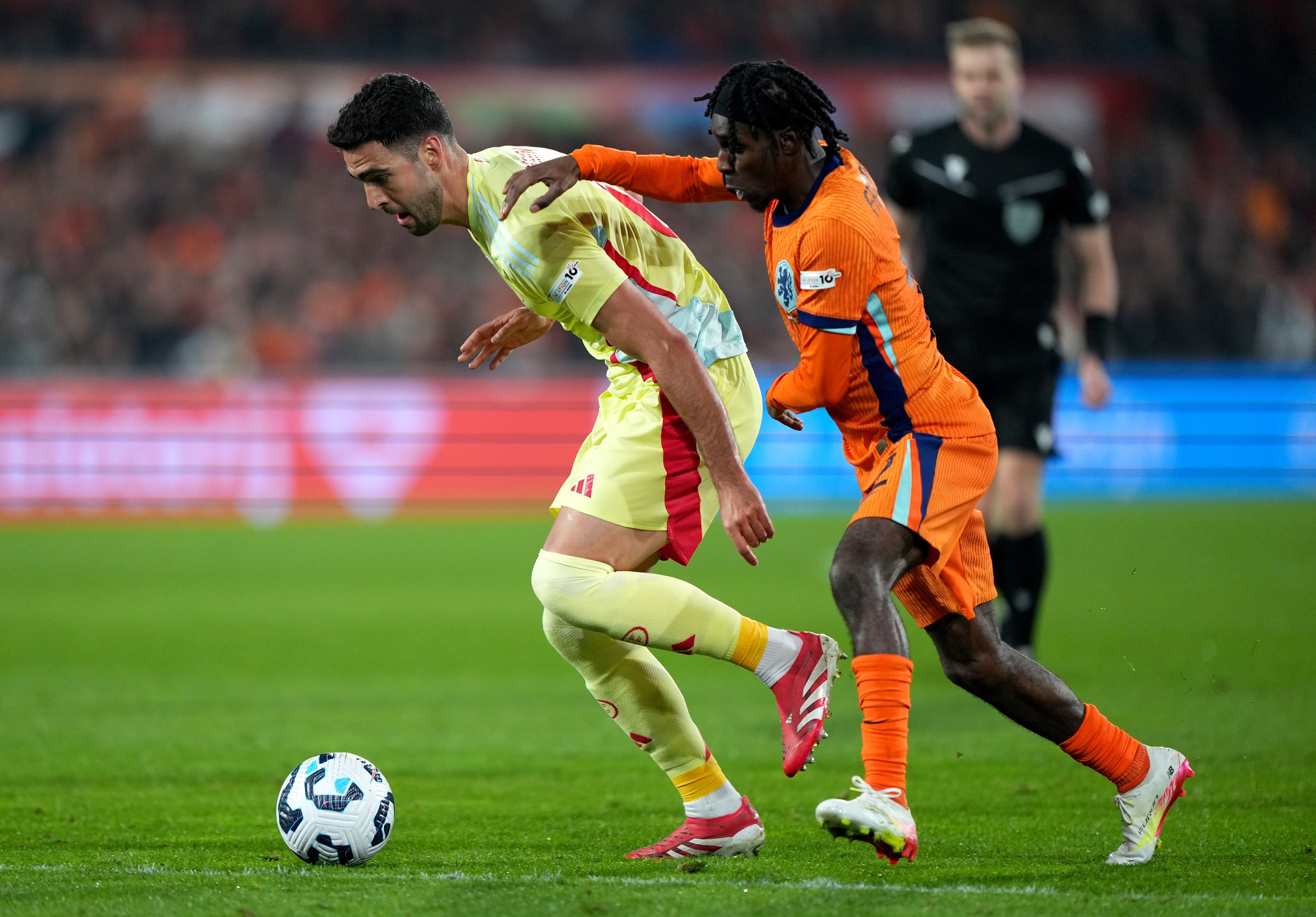 Jeremie Frimpong grabs Mikel Merino's shoulder during Netherlands v Spain.